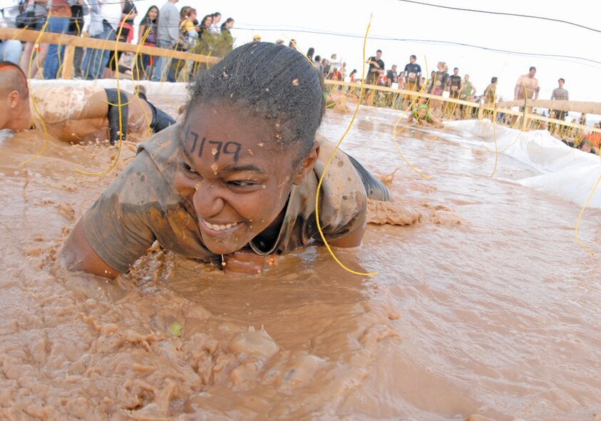 Senior Airman Danielle Sturdivant, 56th Communications Squadron, crawls through the electric eel obstacle Jan. 14 during the Tough Mudder at the Mesa Proving Grounds. The yellow wires contained electricity and would shock the person touching it. (U.S. Air Force photo/Airman 1st Class David Owsianka)