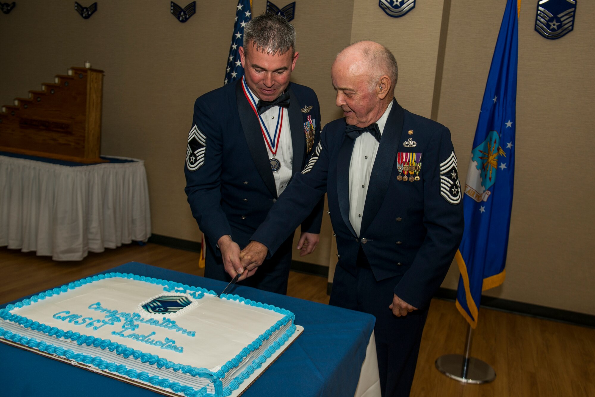 U.S. Air Force Chief Master Sgt. Maxie Gainey, left, and retired Chief Master Sgt. Earl Hendrix cut the ceremonial cake during a chief recognition ceremony Jan. 12, 2013, at Moody Air Force Base, Ga. It is tradition for the ranking chief master sergeant inductee and senior ranking chief master sergeant to cut the cake. (U.S. Air Force photo by Staff Sgt. Jamal D. Sutter/Released)