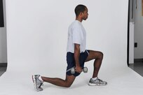 Dumbbell walking lunge
Hold a pair of dumbbells at arm?s length next to sides, palms facing each other. Step forward with left leg and slowly lower body until knee is bent at least 90 degrees. Pause and then push up to starting position quickly. Complete desired number of reps with left leg and then repeat with right leg. ( U.S. Air Force photo by Don Lindsey)
