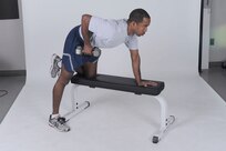 Dumbbell single-arm row
Grab a dumbbell with left hand and place right hand and right knee on a flat bench. Lower back should be naturally arched and torso roughly parallel to the floor. Keep upper arm perpendicular to body and row the weight toward side of chest. Pause, then return to starting position. Complete all reps, then switch sides and repeat. ( U.S. Air Force photo by Don Lindsey )
