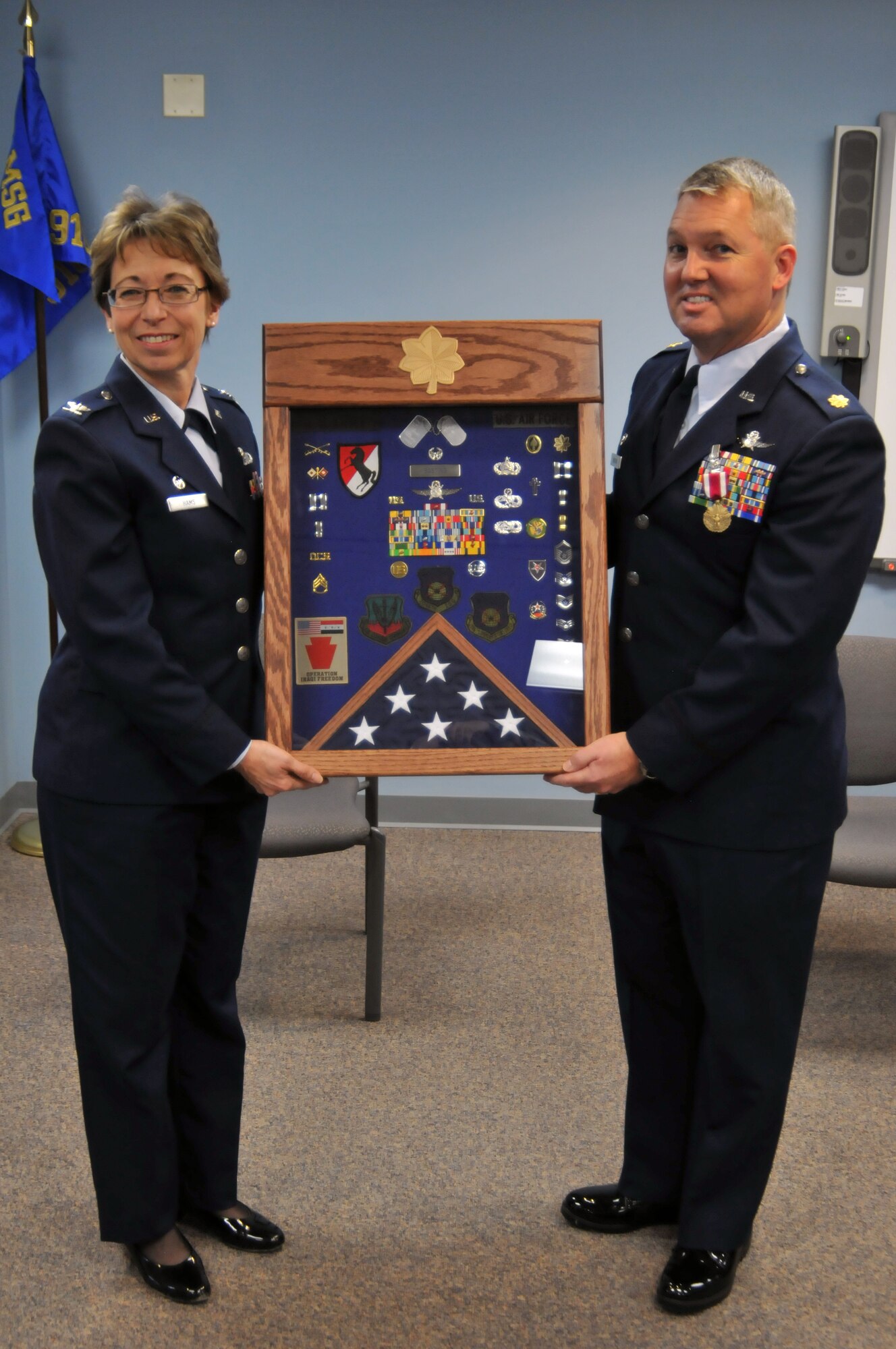 YOUNGSTOWN AIR RESERVE STATION, Ohio – Col. Teresa Hams, 910th Mission Support Group commander, presents Maj. Richard Basting, former 910th Communications Squadron commander, a shadow box as a token of appreciation for his hard work and distinguished career during a change of command ceremony, January 12. Lt. Col. Peter Milkovich took command of the 910th Communications Squadron from Basting, who is scheduled to retire in March of this year.
