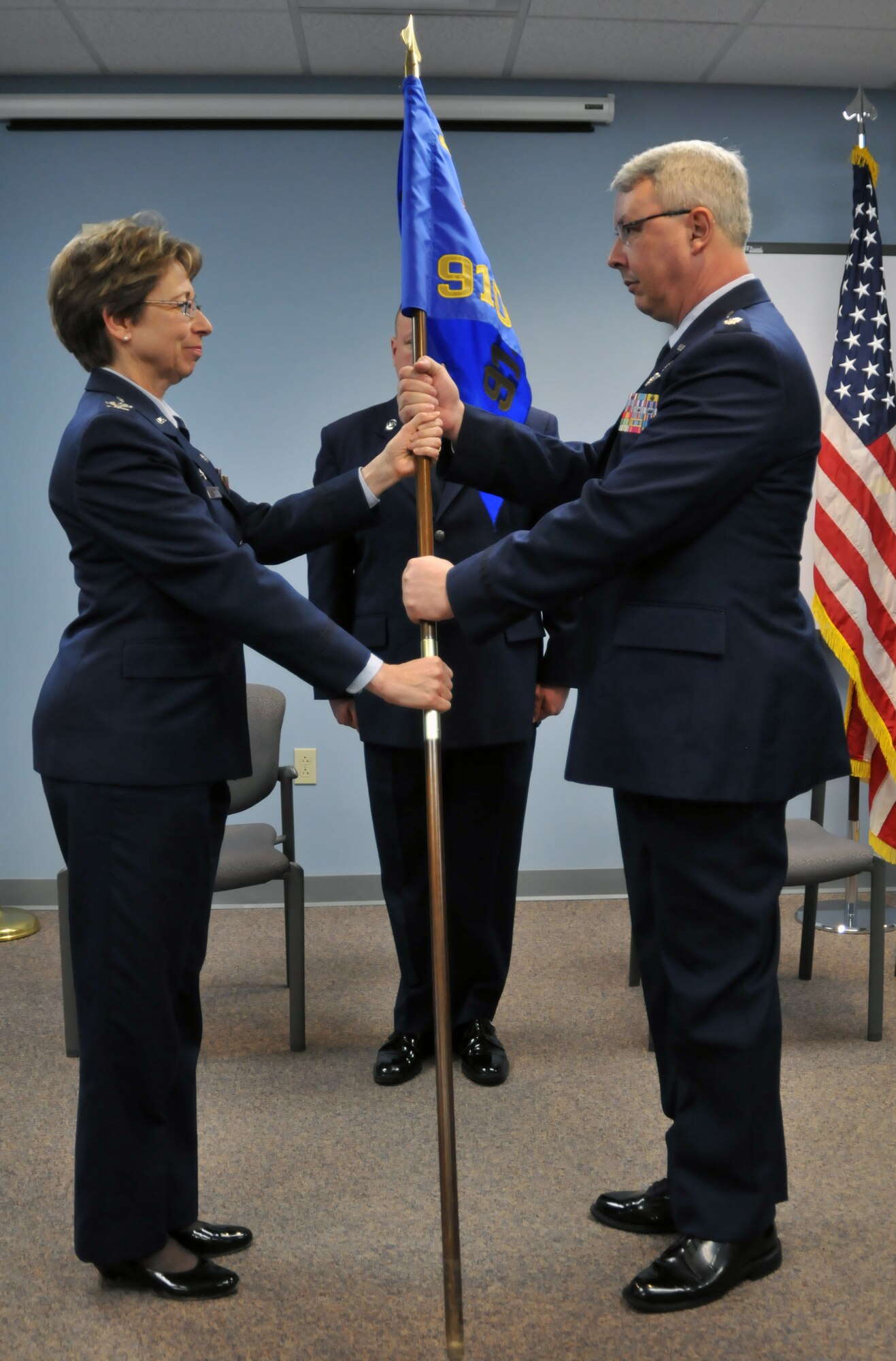 YOUNGSTOWN AIR RESERVE STATION, Ohio – Col. Teresa Hams, 910th Mission Support Group commander, passes the squadron guideon to Lt. Col. Peter Milkovich during a Communications Squadron change of command ceremony here, January 12. The passing of the guideon symbolizes the transfer of command from the outgoing commander to the incoming commander. Milkovich took command of the 910th Communications Squadron from Maj. Richard Basting prior to his retirement.