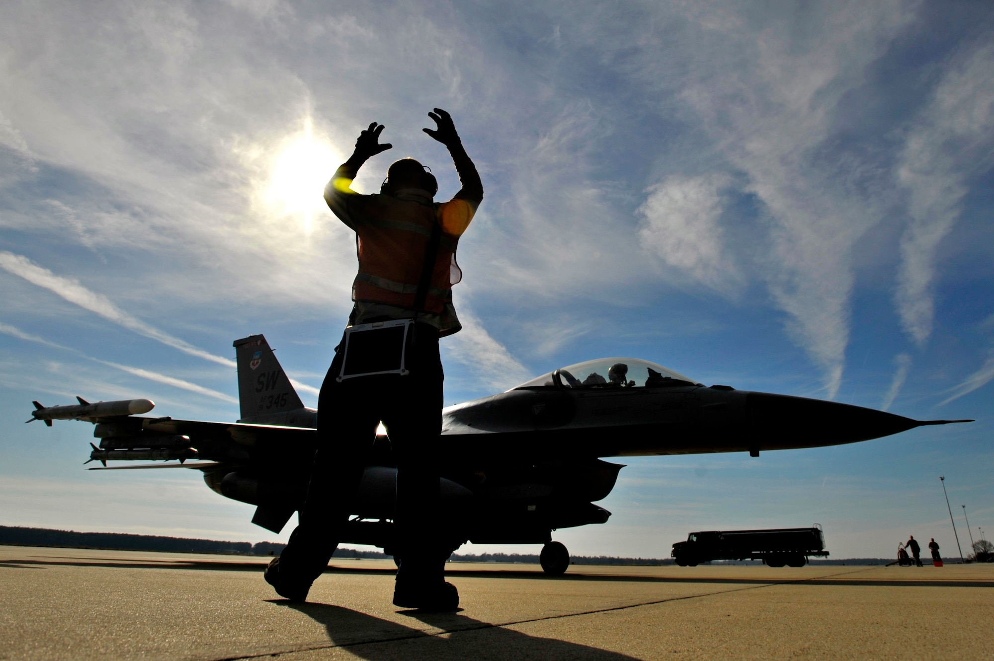 U.S. Air Force Senior Airman Dakota Brightwell, 20th Aircraft Maintenance Squadron crew chief, launches a 79th Fighter Squadron fighter pilot out of the “hot pit” area after his aircraft was refueled, Jan. 10, 2013, Shaw Air Force Base, S.C. Fuels operators and crew chiefs such as Brightwell performed hot pit refueling procedures for both the 55th and 79th Fighter Squadrons. Hot pit refueling is a procedure usually performed in a combat situation to rapidly refuel aircraft while their engines are running resulting in a speedy refuel to thrust pilots back into the fight. (U.S. Air Force photo by Staff Sgt. Kenny Holston)(Released)