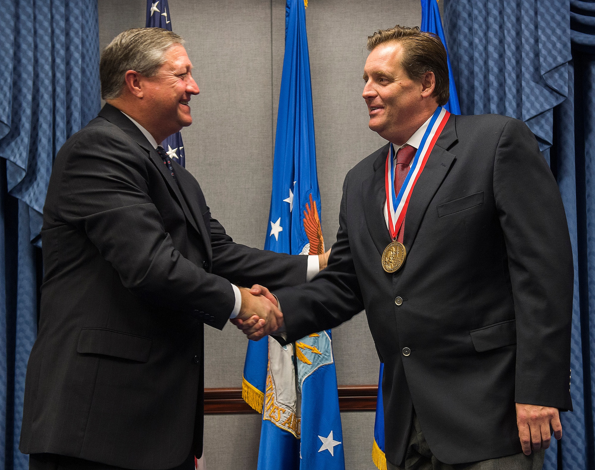 Secretary of the Air Force Michael Donley (left) congratulates Chris Sehman after presenting him with the 2011 Zachary and Elizabeth Fisher Distinguished Civilian Humanitarian Service Award during a ceremony held in the Pentagon, Washington, D.C., Jan. 10, 2013. Sehman distinguished himself as a local community and business leader in the Florida Emerald Coast area. He served as an Honorary Commander for the 36th Electronic Warfare Squadron at Eglin Air Force Base, and the 1st Special Operations Wing at Hurlburt Field, Fla., and was a staunch advocate for the Special Operations Warrior Foundation and Wounded Warrior Program. (U.S. Air Force photo/Jim Varhegyi)