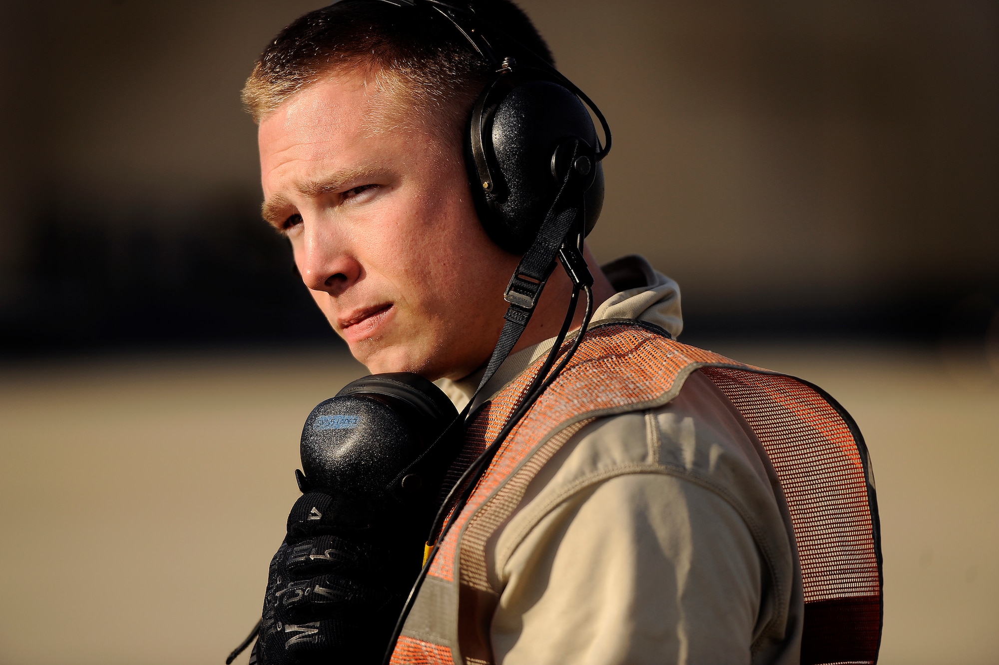 U.S. Air Force Senior Airman Dakota Brightwell, 20th Aircraft Maintenance Squadron crew chief, looks across the flightline as he communicates via headset with F-16 Fighting Falcon pilots while they refuel, Jan. 10, 2013, Shaw Air Force Base, S.C. Fuels operators and crew chiefs such as Brightwell performed hot pit refueling procedures for both the 55th and 79th Fighter Squadrons. Hot pit refueling is a procedure usually performed in a combat situation to rapidly refuel aircraft while their engines are running resulting in a speedy refuel to thrust pilots back into the fight. (U.S. Air Force photo by Staff Sgt. Kenny Holston)(Released)