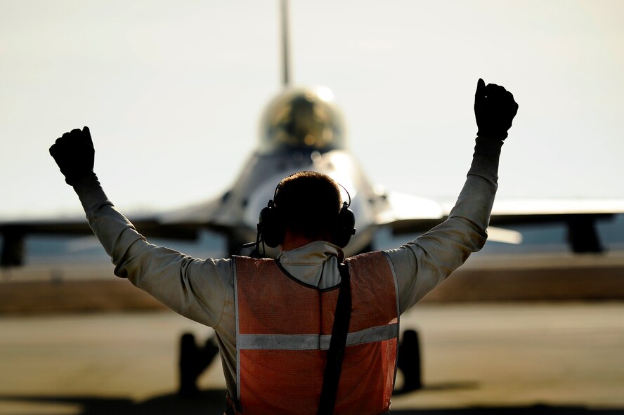 U.S. Air Force Senior Airman Dakota Brightwell, 20th Aircraft Maintenance Squadron crew chief, marshals an F-16 Fighting Falcon pilot into the “hot pit” area to begin refueling the pilots aircraft, Jan. 10, 2013, Shaw Air Force Base, S.C. Fuels operators and crew chiefs such as Brightwell performed hot pit refueling procedures for both the 55th and 79th Fighter Squadrons. Hot pit refueling is a procedure usually performed in a combat situation to rapidly refuel aircraft while their engines are running resulting in a speedy refuel to thrust pilots back into the fight. (U.S. Air Force photo by Staff Sgt. Kenny Holston)(Released)