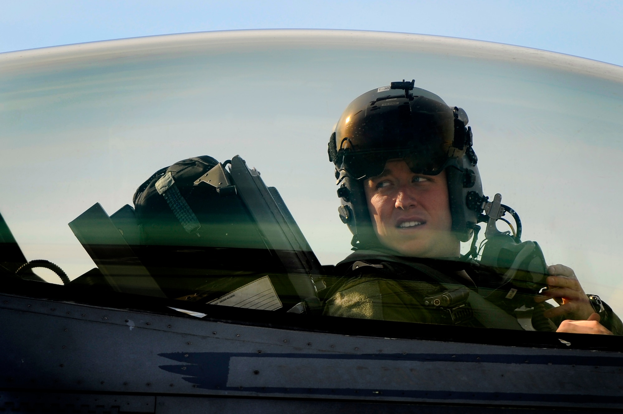 A U.S. Air Force F-16 Fighting Falcon pilot with the 79th Fighter Squadron looks toward the back rear of his aircraft while communicating with crew chiefs on the ground as his jet is refueled, Jan. 10, 2013, Shaw Air Force Base, S.C. Fuels operators and crew chiefs performed hot pit refueling procedures for both the 55th and 79th Fighter Squadrons. Hot pit refueling is a procedure usually performed in a combat situation to rapidly refuel aircraft while their engines are running resulting in a speedy refuel to thrust pilots back into the fight. (U.S. Air Force photo by Staff Sgt. Kenny Holston)(Released)