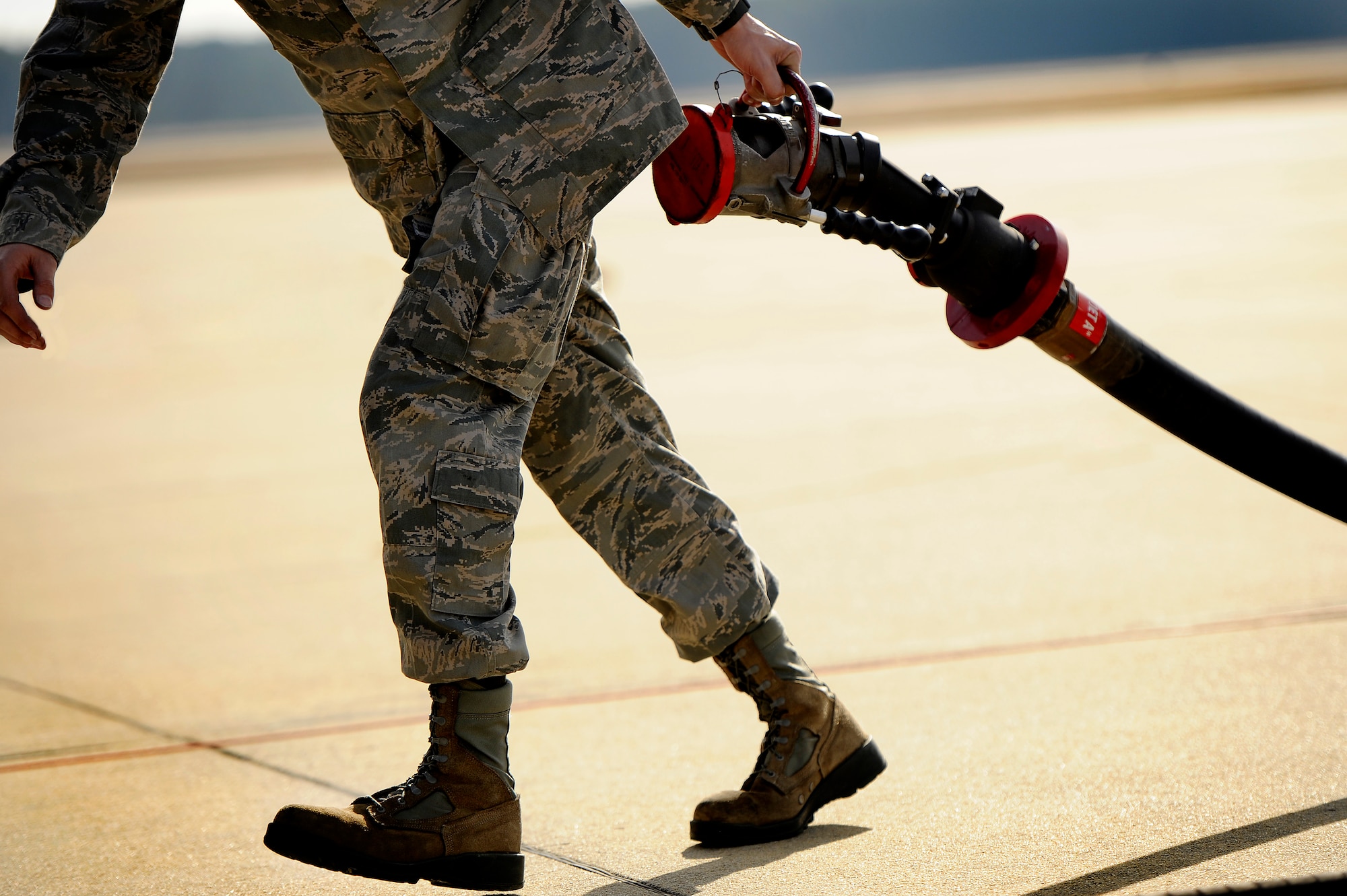 U.S. Air Force Airman 1st Class Jonathan Hinesley, 20th Logistics Readiness Squadron fuels operator drags a fuel hose away from an F-16 Fighting Falcon after refueling the aircraft, Jan. 10, 2013, Shaw Air Force Base, S.C. Hinesley and other fuels operators and crew chiefs performed hot pit refueling procedures for both the 55th and 79th Fighter Squadrons. Hot pit refueling is a procedure usually performed in a combat situation to rapidly refuel aircraft while their engines are running resulting in a speedy refuel to thrust pilots back into the fight. (U.S. Air Force photo by Staff Sgt. Kenny Holston)(Released)