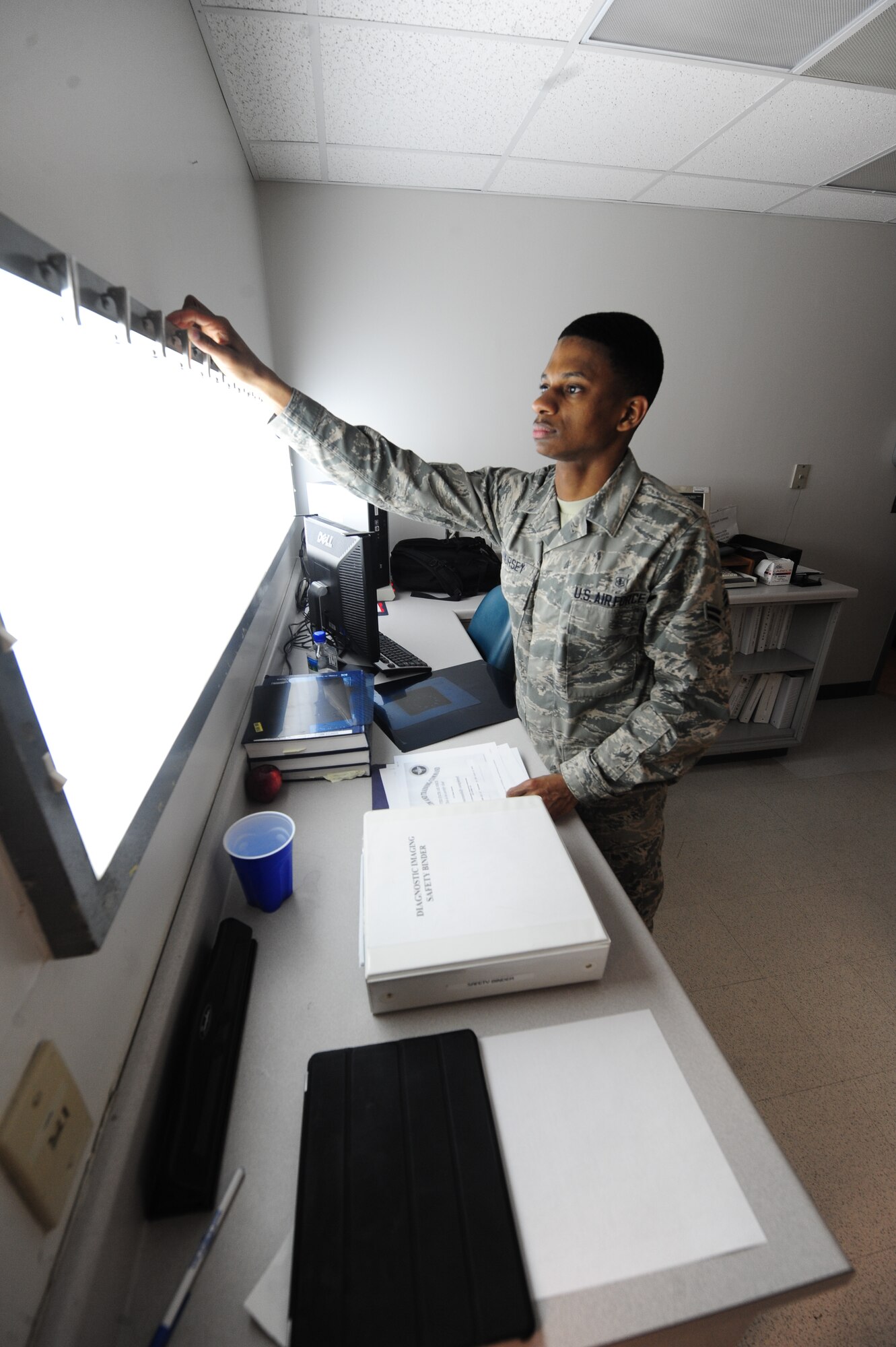 WHITEMAN AIR FORCE BASE, Mo. -- Airman 1st Class Isaiah Hursey, 509th Medical Support Squadron medical logistics customer service technician, prepares to change fluorescent lamps on an X-ray viewer, Jan. 3. X-ray viewer bulbs are part of the supply items medical logistics Airmen are responsible for providing. (U.S. Air Force photo/Staff Sgt. Nick Wilson) (Released)