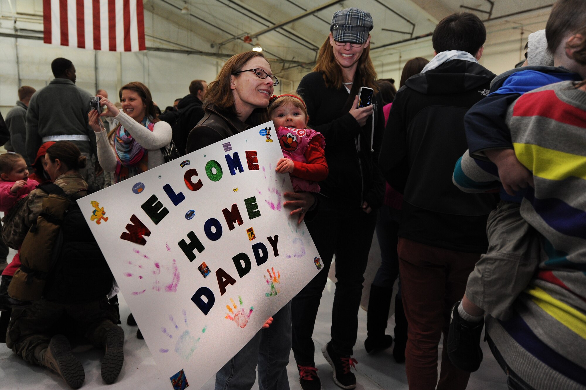 Friends and family members wait for deployed Airmen to return during Operation Homecoming at Cannon Air Force Base, N.M., Jan. 7, 2013. Operation Homecoming is a monthly event that reunites Cannon's Air Commandos with their loved ones.  (U.S. Air Force photo/Senior Airman Jette Carr)