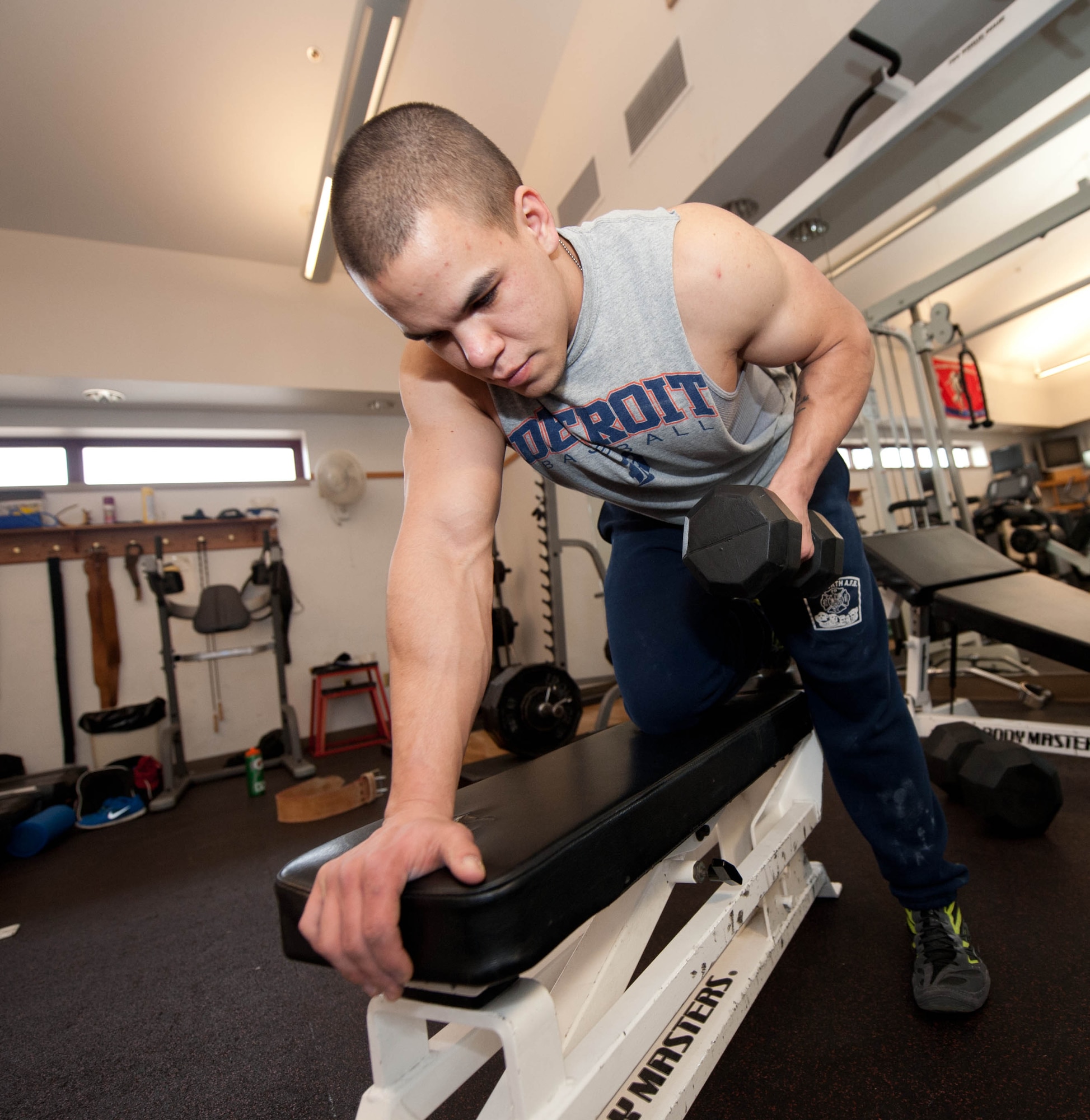 Senior Airman Brandon Stout, 28th Civil Engineer Squadron fire and emergency services driver operator, performs dumbbell rows at the fire station on Ellsworth Air Force Base, S.D., Jan. 8, 2013. The 22-year-old from Holly, Mich., has been powerlifting for eight months and utilizes the gym on base and at the Fire Department to work out. He credits a strict six-day-diet for all of the results he obtained in his primary workouts including squat, bench press and dead lift. (U.S. Air Force photo by Airman 1st Class Zachary Hada/Released)