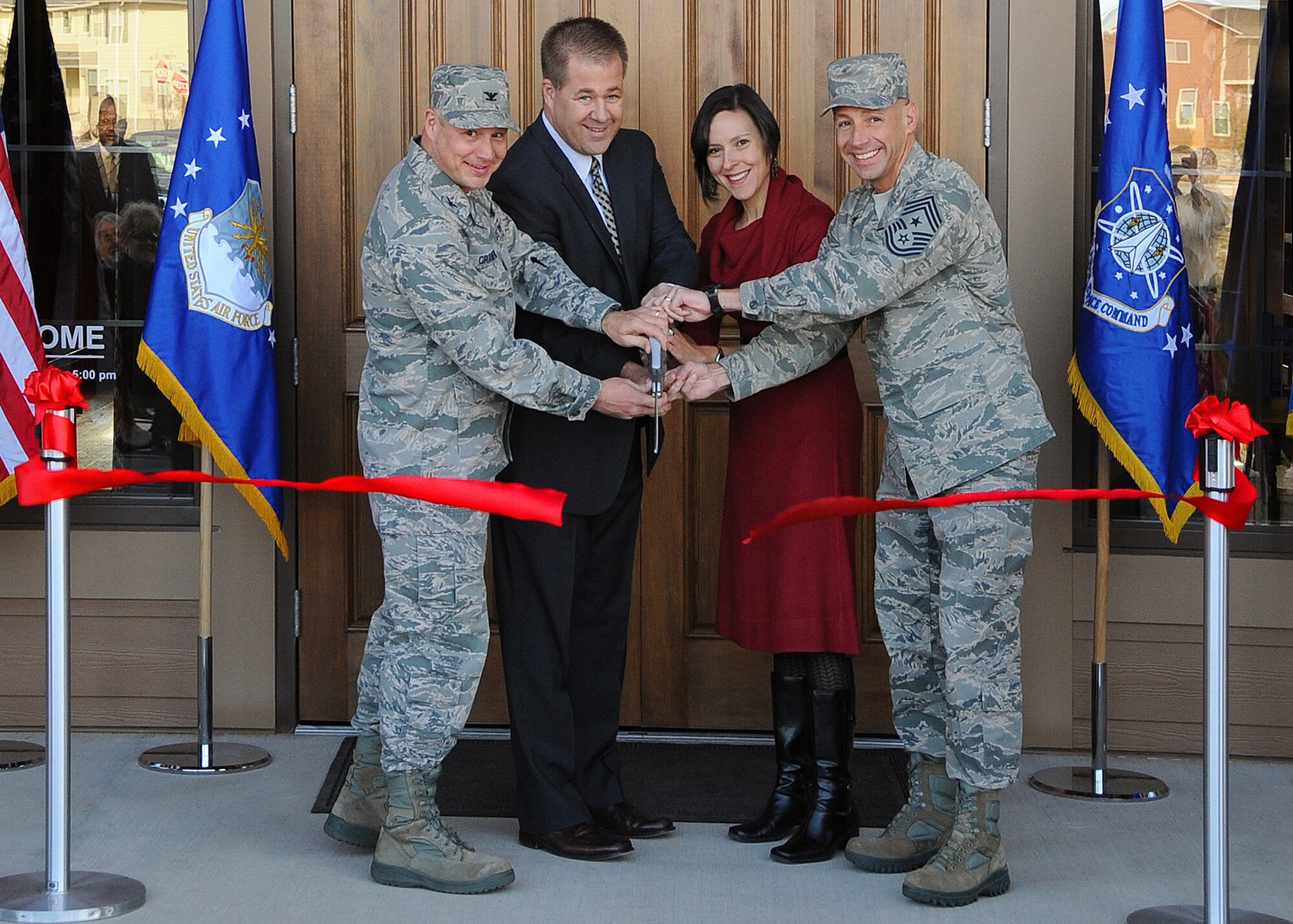 PETERSON AIR FORCE BASE, Colo. – (left to right) Col. Chris Crawford, 21st Space Wing commander, Peter Sims, TVC project director, Joey Sanchez, 21st Civil Engineer Squadron Capital Asset Management chief, and Chief Master Sgt. Richard Redman, 21st SW command chief, cut the ribbon to the new Tierra Vista community center here. The center offers a fitness area, multipurpose room, kitchen and adjoining play area for kids. (U.S. Air Force photo/Duncan Wood)