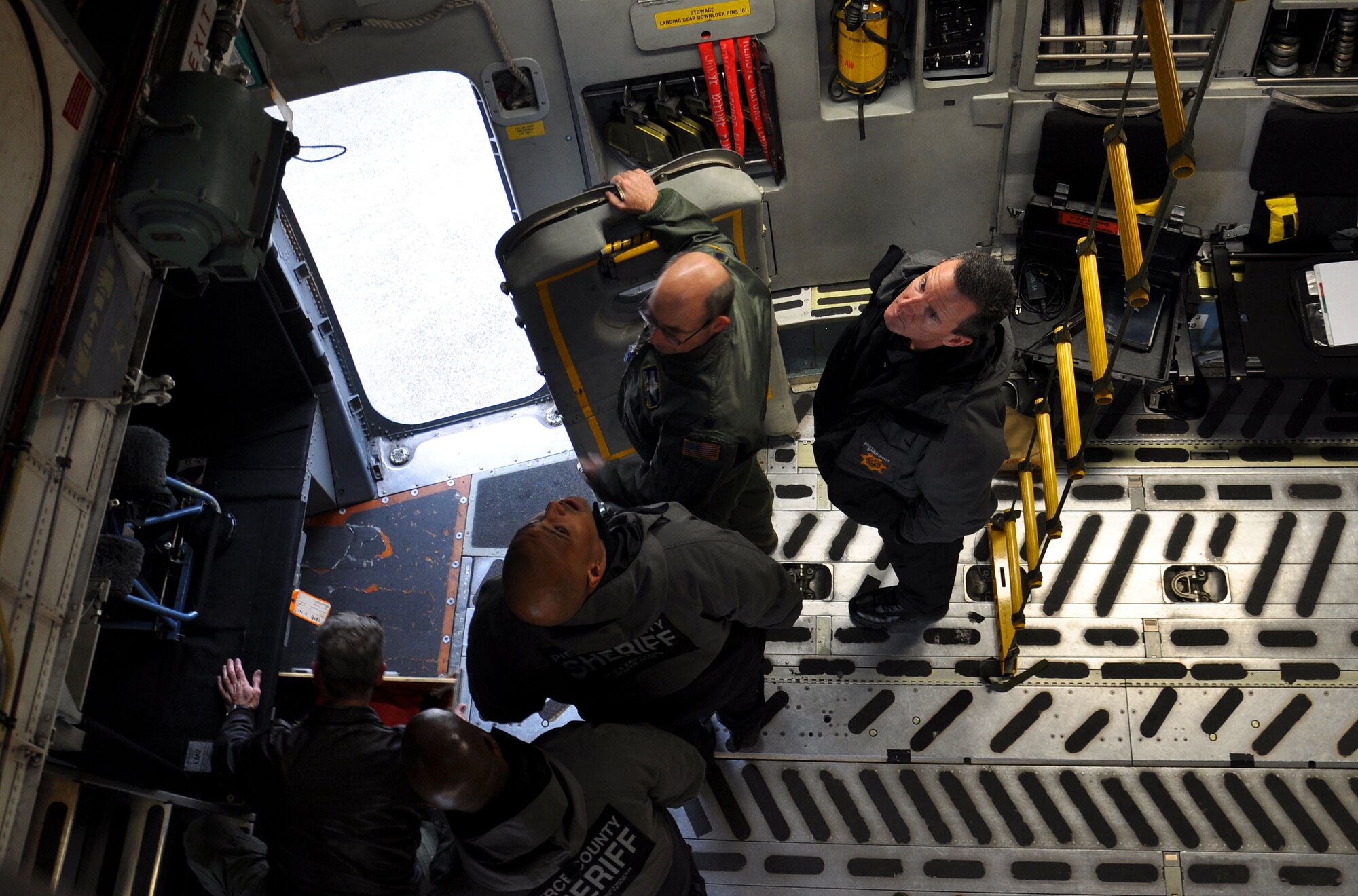 Lt. Col. Christopher Von Thaden (flightsuit) 728th Airlift Squadron director of operations, instructs members of the Pierce County Metro Dive Team from Tacoma, Wash. on the capabilities and various entry and exit points of the C-17 Globemaster III at McChord Field, Wash., Jan. 10, 2013. The dive team visited McChord to receive training on the aircraft, so they would be ready for an incident response in the case of an off-base water landing. (U.S. Air Force photo by Airman 1st Class Madelyn McCullough)