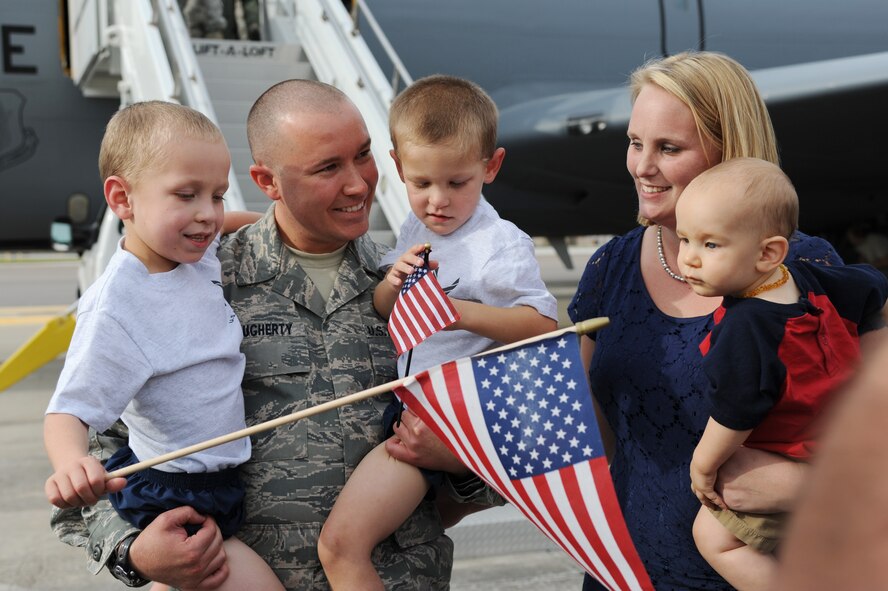 Senior Airman Robert Dougherty, 927th Maintenance Squadron, smiles and embraces his family at MacDill Air Force Base, Florida January 13, 2013.  Dougherty had been deployed for six months with the 927th Air Refueling Wing, helping his deployed unit complete over 50,000 flying hours in one year.  