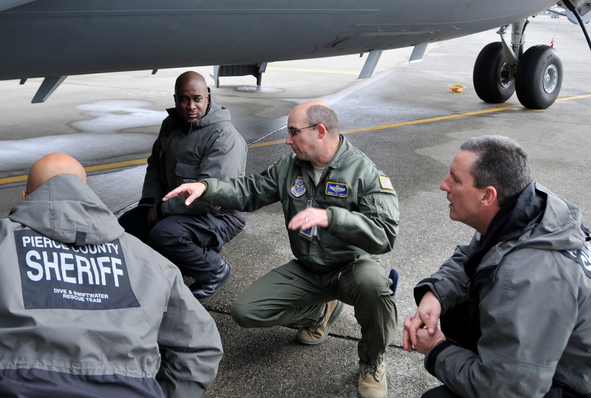 Lt. Col. Christopher Von Thaden (center) 728th Airlift Squadron director of operations, instructs members of the Pierce County Metro Dive Team from Tacoma, Wash. on the capabilities and various entry and exit points of the C-17 Globemaster III at McChord Field, Wash., Jan. 10, 2013. The dive team visited McChord to receive training on the aircraft, so they would be ready for an incident response in the case of an off-base water landing. (U.S. Air Force photo by Master Sgt. Jake Chappelle)