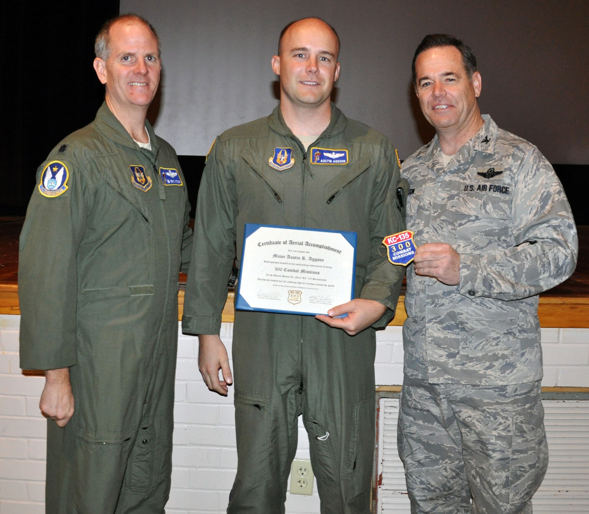 Col. Mark S. Larson, commander of the 931st Air Refueling Group, and Lt. Col. Eric Vitosh, commander of the 18th Air Refueling Squadron, present a certificate and patch commemorating 300 combat missions flown to Maj. Austin Aggson, a pilot assigned to the 18 ARS, at McConnell Air Force Base, Kan., Jan. 14, 2013. Aggson had just returned from deployment. (U.S. Air Force photo by 1st Lt. Zach Anderson)