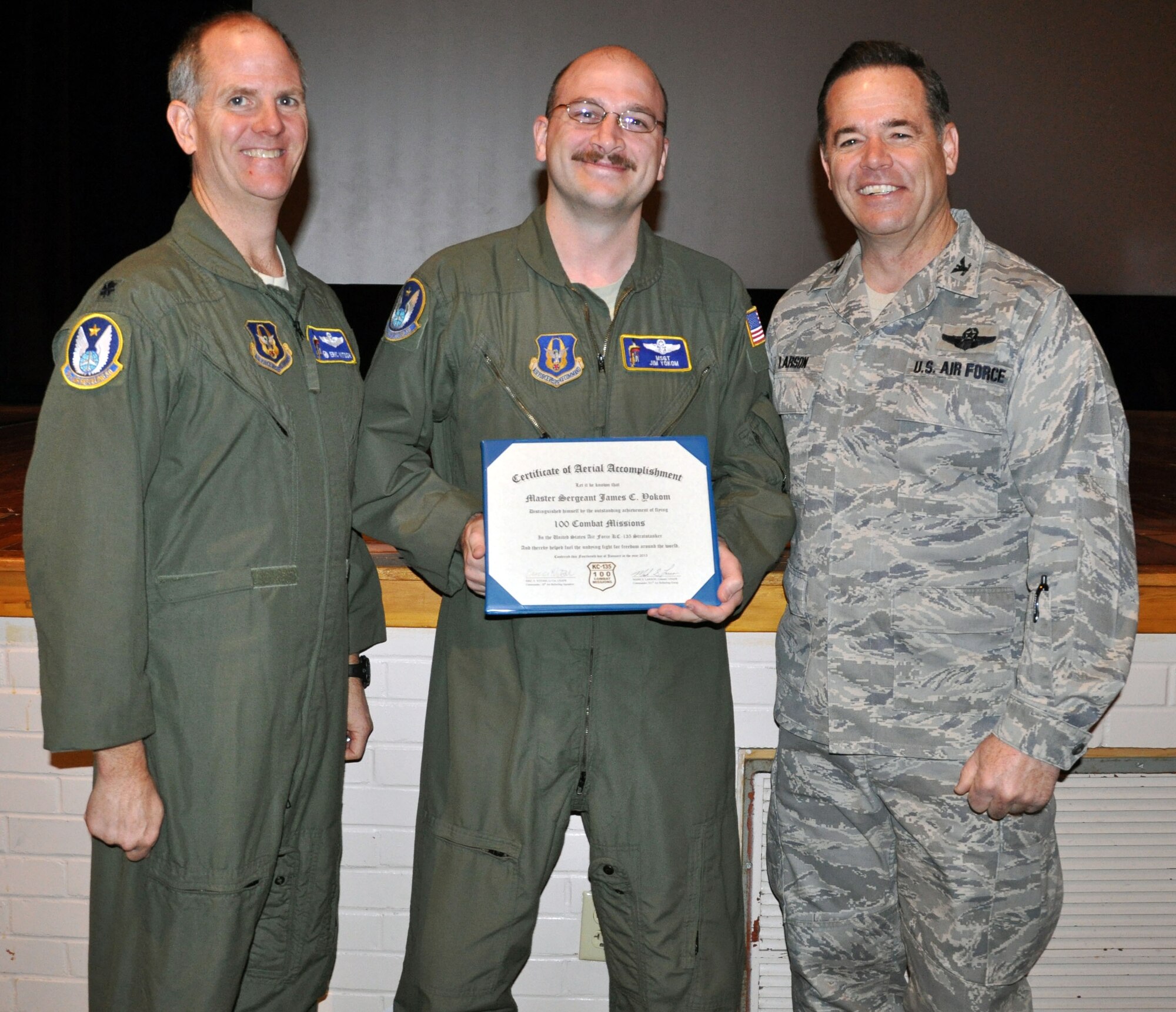 Col. Mark S. Larson, commander of the 931st Air Refueling Group, and Lt. Col. Eric Vitosh, commander of the 18th Air Refueling Squadron, present a certificate commemorating 100 combat missions flown to Master Sgt. James Yokom, a boom operator assigned to the 18 ARS.  Yokom had just returned from deployment. (U.S. Air Force photo by 1st Lt. Zach Anderson)
