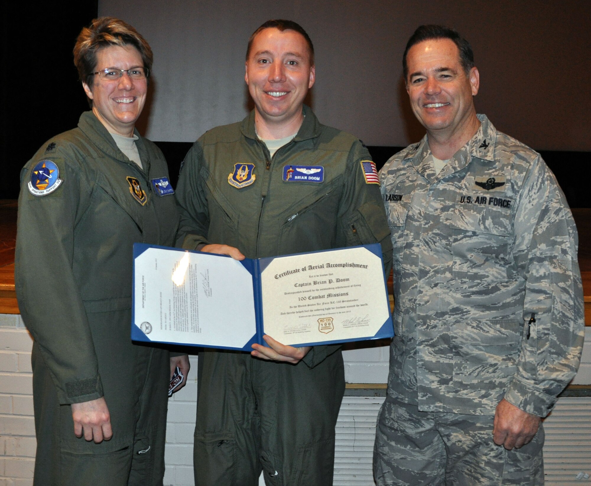 Col. Mark S. Larson, commander of the 931st Air Refueling Group, and Lt. Col. Stacy Wharton, commander of the 931st Operations Support Squadron, present a certificate commemorating 100 combat missions flown to Capt. Brian Doom, a pilot assigned to the 931 OSS, McConnell Air Force Base, Kan., Jan. 14, 2013.  Doom had just returned from deployment. (U.S. Air Force photo by 1st Lt. Zach Anderson)