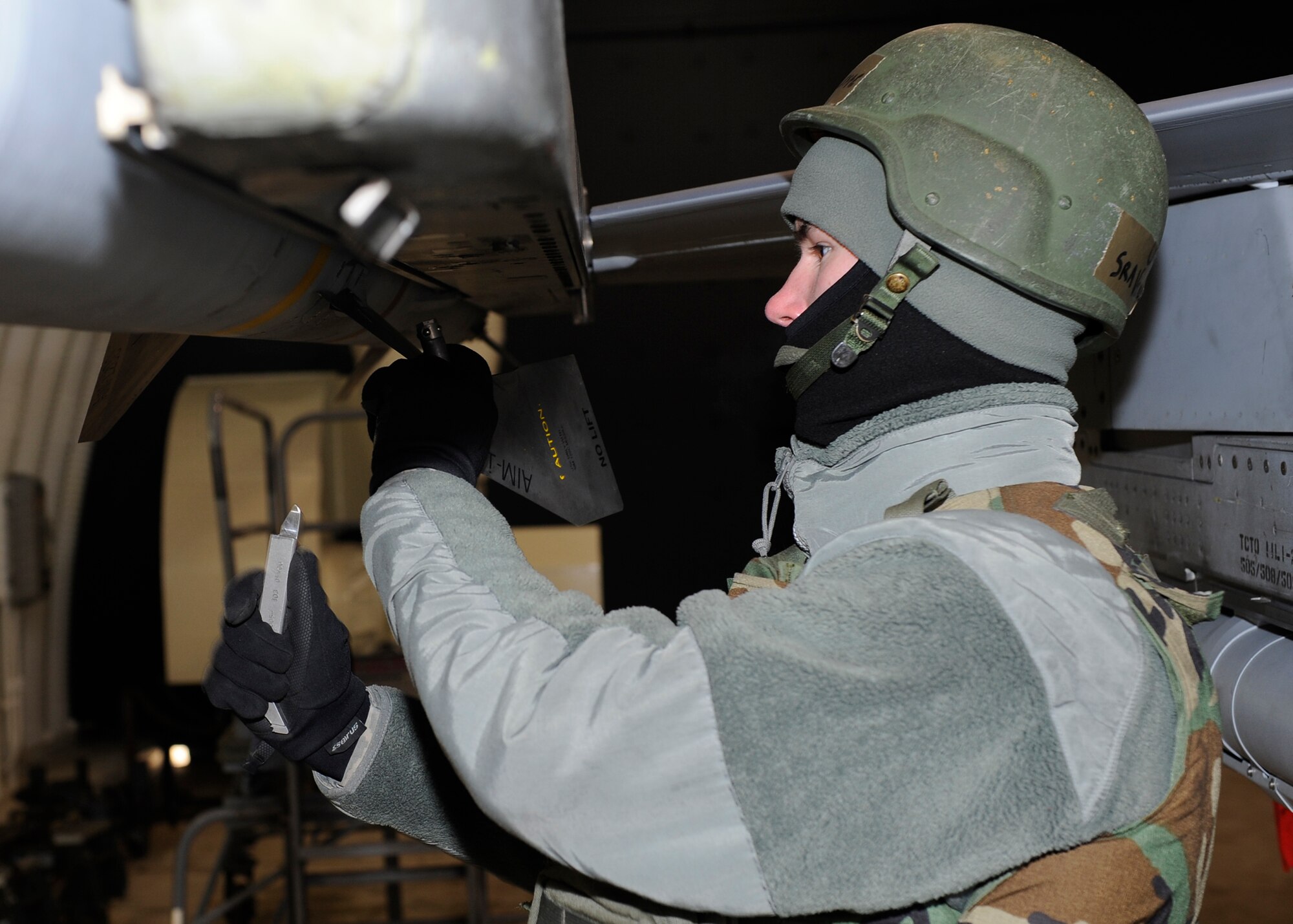 Senior Airman Vincent Gleffe, 8th Aircraft Maintenance Squadron, places fins on a missile during Beverly Midnight 13-1 at Kunsan Air Base, Republic of Korea, Jan. 14, 2013. The 8th AMXS worked quickly to make the F-16 Fighting Falcons were combat-ready for the generation. (U.S. Air Force photo by Senior Airman Marcus Morris/Released)