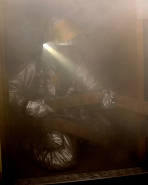 Senior Airman Aaron Strayhorn, 8th Civil Engineer Squadron firefighter, pulls the slack from the fire hose while fighting a fire during Beverly Midnight 13-1 at Kunsan Air Base, Republic of Korea, Jan. 14, 2013. After putting out the fire, the firefighters continued a sweep inside to check for any people still in the building. (U.S. Air Force photo by Senior Airman Marcus Morris/Released)