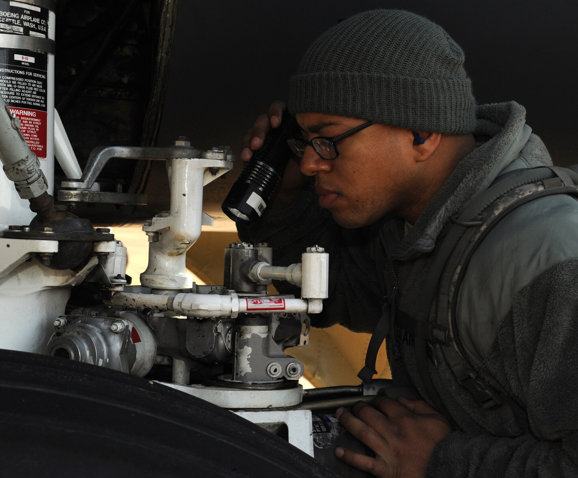 Staff Sgt. Dominique West, 20th Aircraft Maintenance Unit crew chief, ensures the landing gear of a B-52H Stratofortress is properly working on Barksdale Air Force Base, La., Jan. 11. During pre-flight inspections, crew chiefs check the interior and exterior of the aircraft for any abnormalities. (U.S. Air Force photo/Airman 1st Class Benjamin Gonsier)
