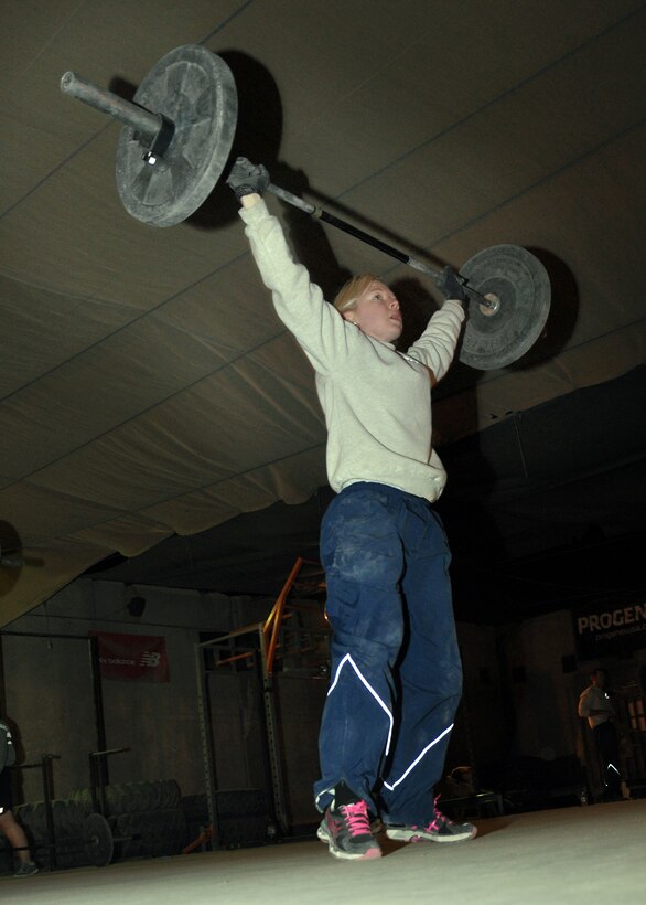 Capt. Lesley Lilly, 451st Expeditionary Force Support Flight commander and a volunteer CrossFit coach at Kandahar Airfield, performs an overhead squat during the 5 a.m. CrossFit class on Jan. 14. Lilly, deployed here from Joint Base San Antonio-Lackland, coaches a 5 a.m. class six days a week. “CrossFit is really good in developing well-rounded athletes because it incorporates so many different types of physical activity,” she said. “The workouts are intended to be constantly varied, high-intensity, functional movements.” (U.S. Air Force photo/Master Sgt. Russell Martin)