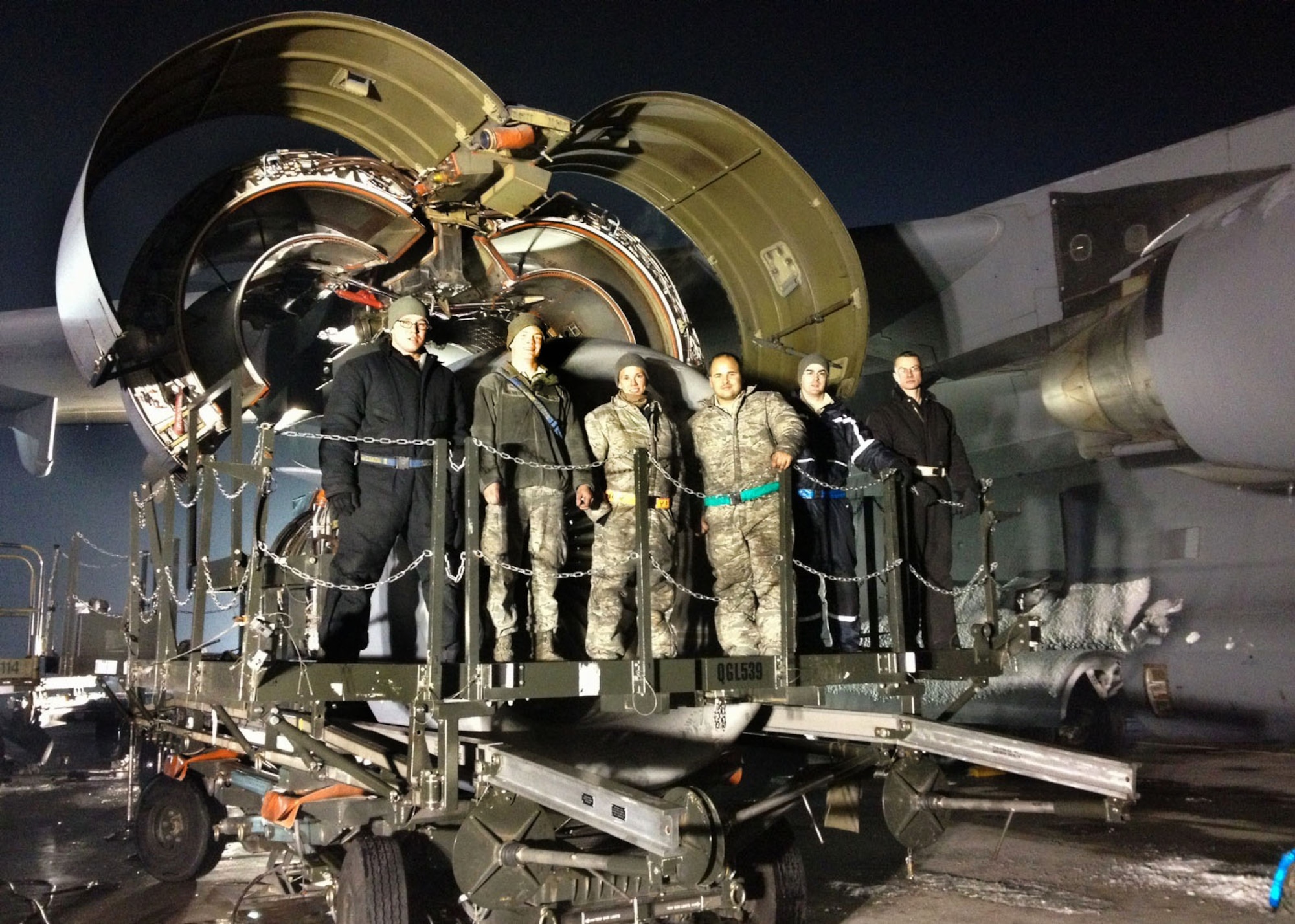 Left to right, Staff Sgt. Jonathan Lamica, Airman 1st Class Christopher McKinstry, Staff Sgt. Andrea Gentsy, Senior Airman Edwin Carrasquillo, Senior Airman Kevin Baker and Staff Sgt. Phillip Budlong, all members of an engine repair team, pause work on an engine change to take a group photo at Transit Center at Manas, Kyrgyzstan, Jan. 13, 2013. Repair teams from the Transit Center, Ramstein Air Base, Germany, and a base in Southwest Asia worked around the clock to complete an engine change, a procedure that doesn’t often happen in a deployed environment. Team members not pictured are: Staff Sgt. Angel Jarramillo, Senior Airman Tiffany Windsor and Airman 1st Class Heather Lopez. (U.S. Air Force photo/Lt. Col. Clinton ZumBrunnen)