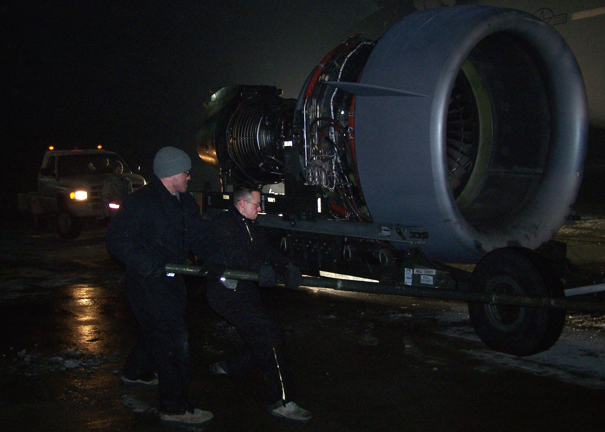 Left, Staff Sgt. Jonathan Lamica, 728th Air Mobility Squadron Operating Location-Alpha engine mechanic, and Staff Sgt. Phillip Budlong, 721st Aircraft Maintenance Squadron engine mechanic,  position a new engine prior for installation at Transit Center at Manas, Kyrgyzstan, Jan. 13, 2013. Budlong is part of a maintenance recovery team from Ramstein Air Base, Germany, that was called upon to assist with an engine change on a C-17 Globemaster III following damage to its number four engine. (U.S. Air Force photo/Master Sgt. James Herron)