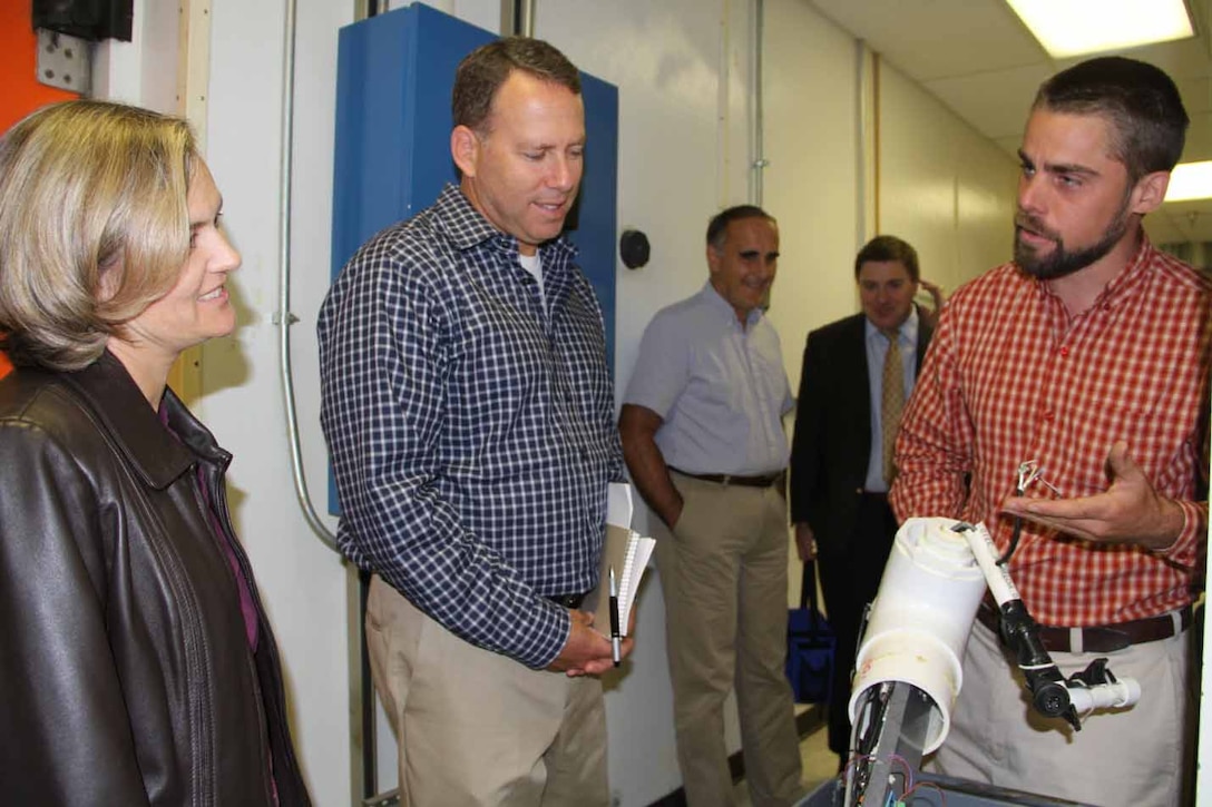 ERDC Cold Regions Research and Engineering Geophysicist Dr. Christopher Polashenski briefs Navy Task Force Climate Change Arctic Affairs Officer Cmdr. Angela Walker and Deputy Director Joseph Brenner.