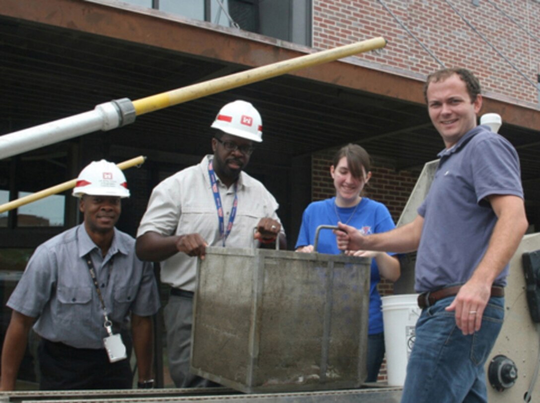 From left to right, Greg Jackson and Rodney Parker, Vicksburg District, and Nicky Hahn and Alan Katzenmeyer, ERDC Environmental Laboratory, remove a live-well basket with fish for museum exhibit from an electro-fishing boat.
