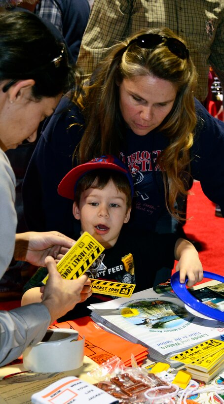 Sara Jones of the U.S. Army Corps of Engineers Sacramento District, left, shares reminders for water safety with a young attendee and his mother at the International Sportsmen’s Expo, Jan. 11, 2012, in Sacramento, Calif. Jones is a park ranger at Stanislaus River Parks near Knights Ferry, Calif. (U.S. Army photo by Robert Kidd/Released)