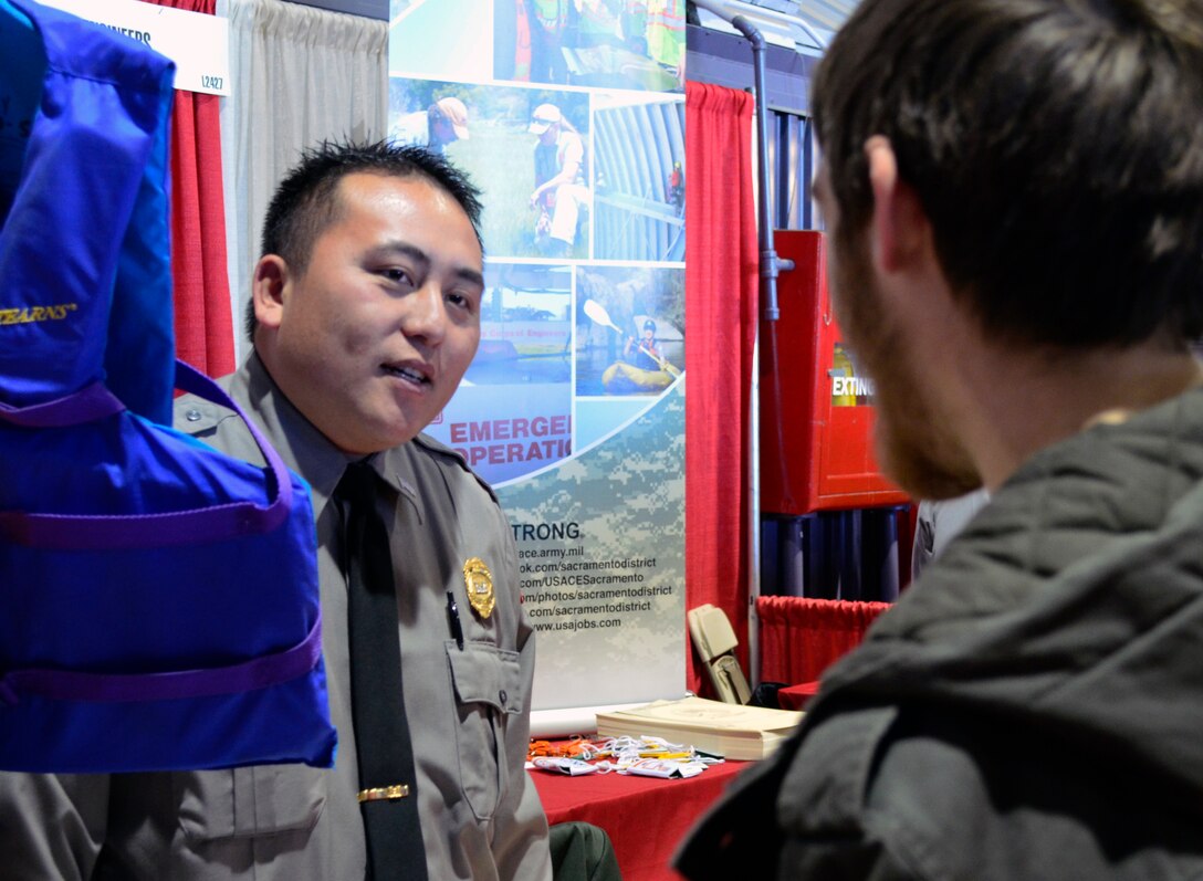 Mongzong Xiong of the U.S. Army Corps of Engineers Sacramento District shares water safety information with a visitor to the International Sportsmen’s Expo, Jan. 11, 2012, in Sacramento, Calif. Xiong is a park ranger at Pine Flat Lake near Piedra, Calif. (U.S. Army photo by Robert Kidd/Released)