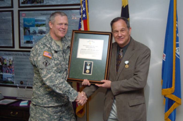 Col Jordan presents Jim Brozena with the Commander's Award for Public Service.