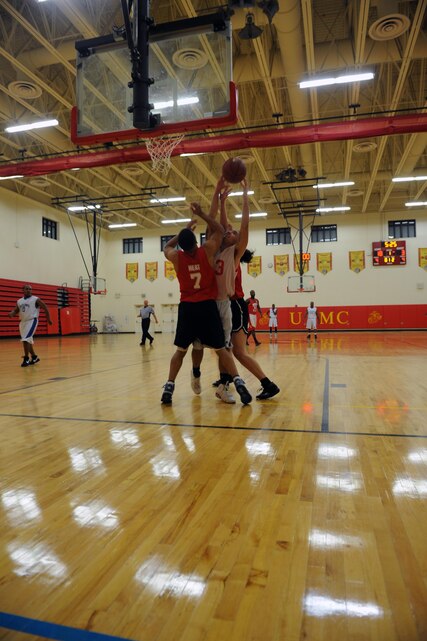 Marke Kowalik, player with Marine Corps Air Facility’s intramural basketball team, rebounds the ball between two players from the Marine Corps Embassy Security Group team, Charles Jones and Madea Davis, at the Barber Physical Fitness Center on Jan. 14. MCESG wasn’t able to catch up in the second half and lost, 49-36.