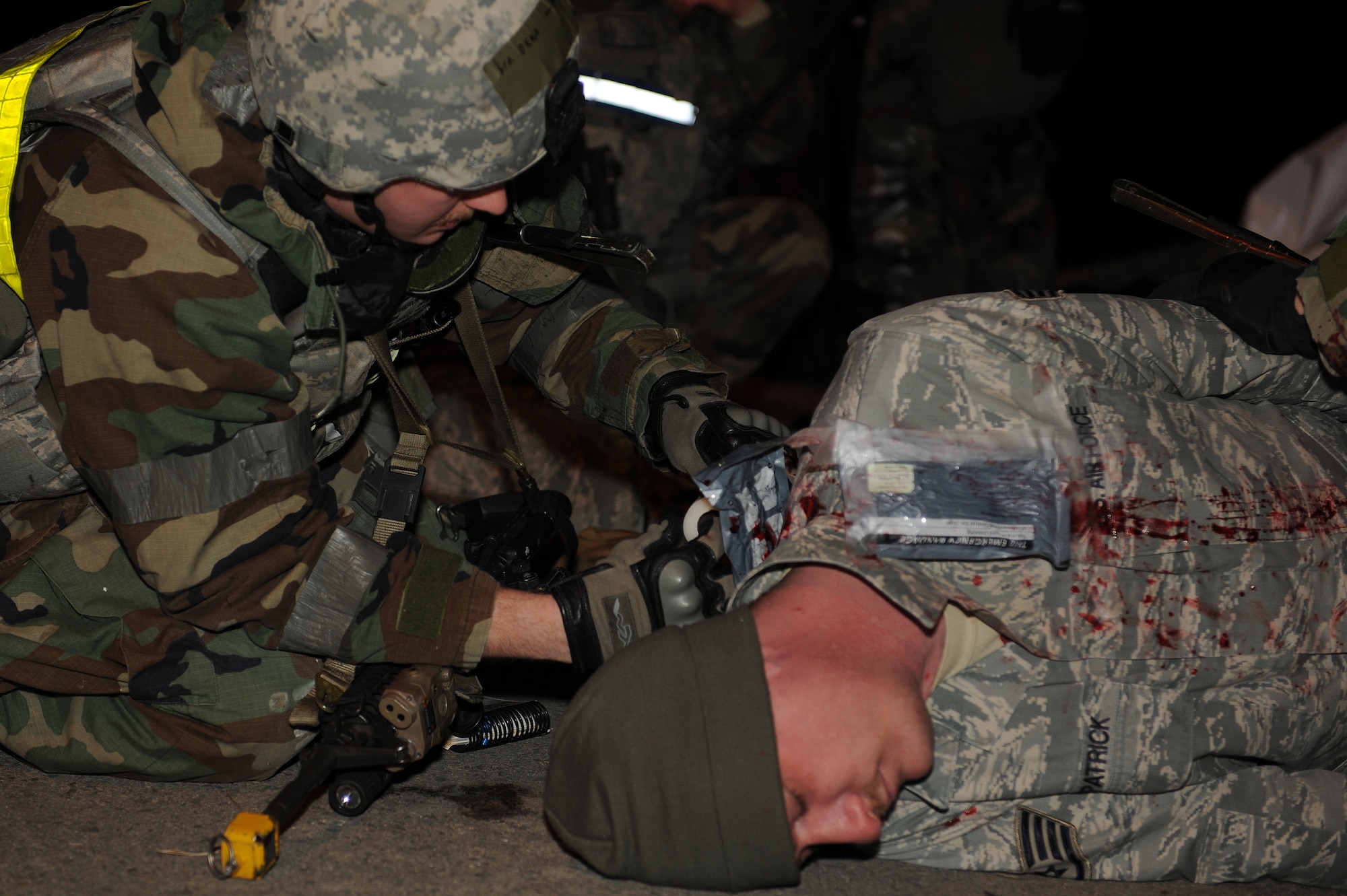 Senior Airman Kameron Deno, 8th Security Forces Squadron, treats the wounds of Staff Sgt. Bryce Fitzpatrick, 8th Fighter Wing role player, following a simulated attack during Exercise Beverly Midnight 13-1 at Kunsan Air Base, Republic of Korea, Jan. 16, 2013. Deno attempted to seal off Fitzpatrick’s entrance and exit wounds so he could be transported to the clinic for further assessment and medical treatment. (U.S. Air Force photo by Staff Sgt. Jonathan Fowler/Released)