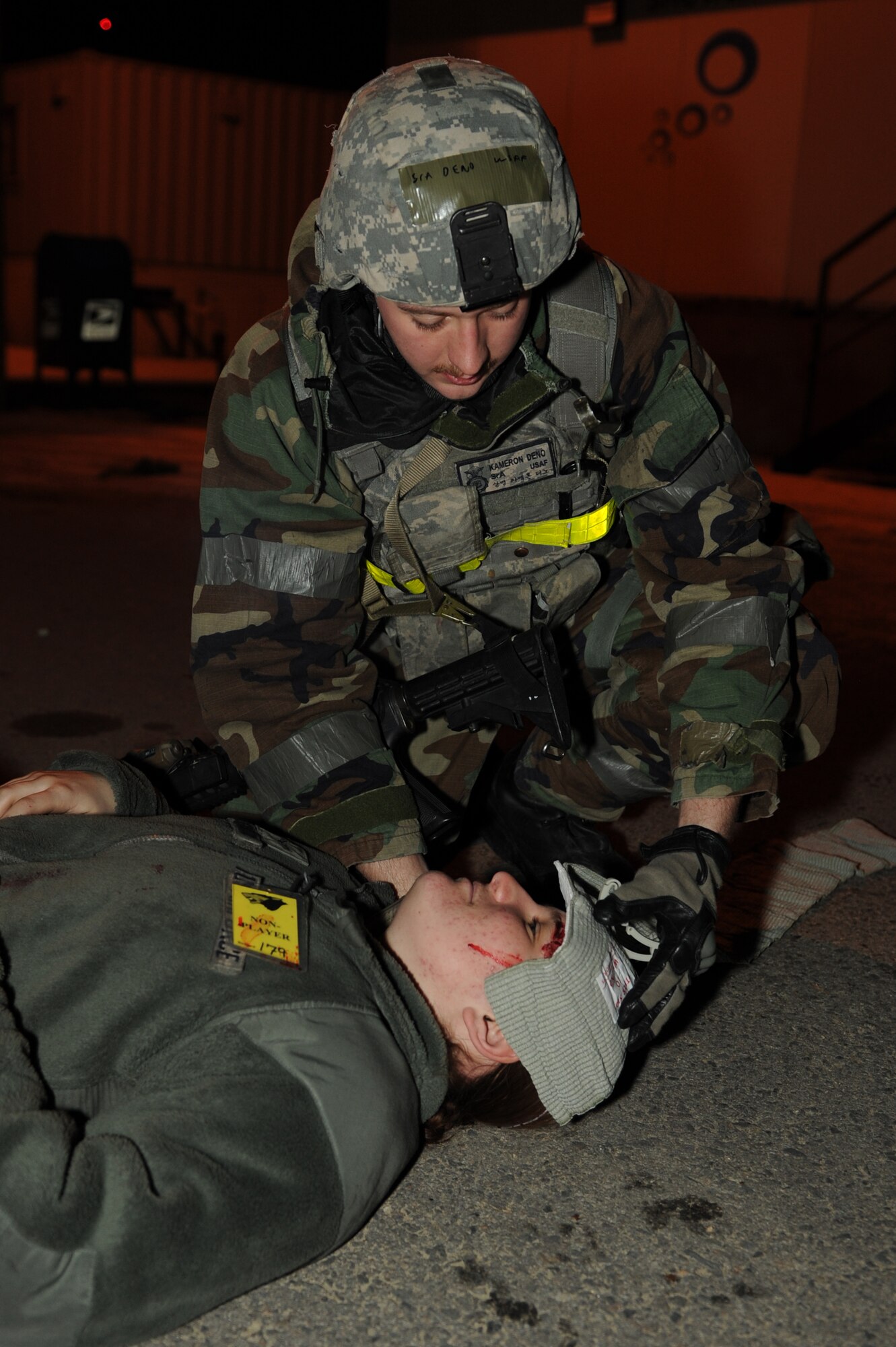 Senior Airman Kameron Deno, 8th Security Forces Squadron, treats Airman 1st Class Crystal MacGirvin’s simulated head wound during a training scenario for Exercise Beverly Midnight 13-1 at Kunsan Air Base, Republic of Korea, Jan. 16, 2013. The scenario tested the security forces ability to respond to and treat injured personnel following a ground attack. (U.S. Air Force photo by Staff Sgt. Jonathan Fowler/Released)