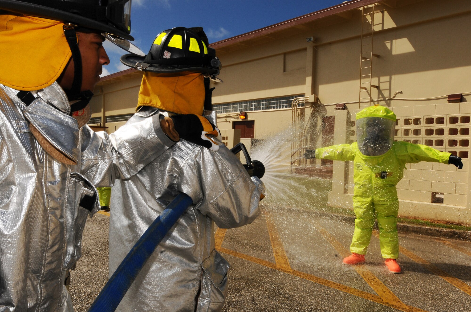 Airmen from the 36th Civil Engineer Squadron decontaminate a 36th Medical Operations Squadron bioenvironmental engineering technician before he exits the cordon of a hazardous material investigation during an operational readiness exercise Andersen Air Force Base, Guam, Jan. 14, 2013. (U.S. Air Force photo by Senior Airman Carlin Leslie/Released)