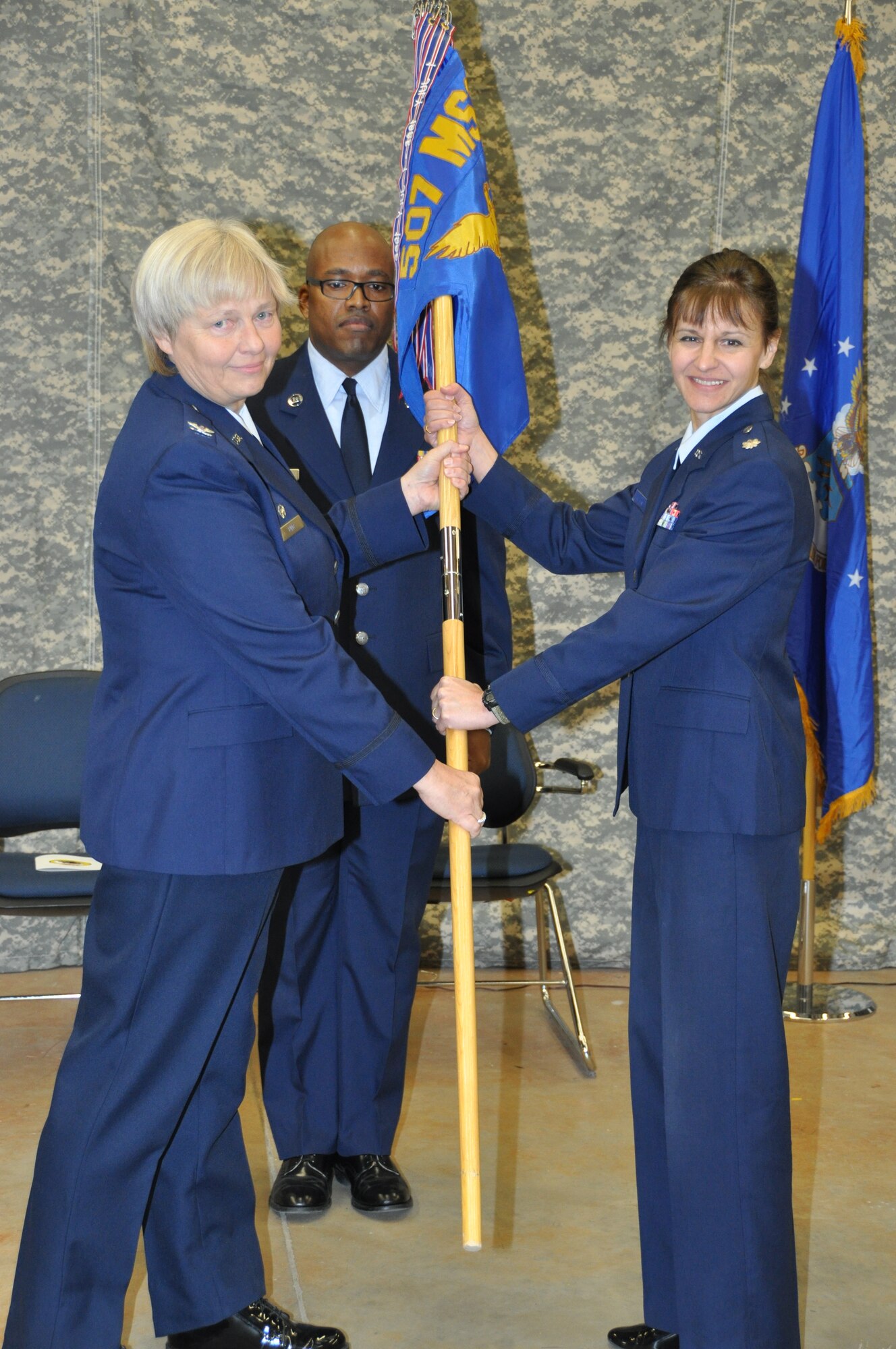 Lt. Col. Patricia Pettine, right, receives the flag from Mission Support Group Commander, Mary Lutz, left, as she assumes command of the 507th Civil Engineer Squadron during a ceremony held January 5, 2013.  Pettine assumes command from Lt. Col. Brian Stahl, the CES commander since 2010.  (U.S. Air Force photo by Senior Airman Mark Hybers)