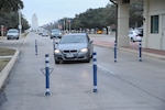 Joint Base San Antonio-Randolph members slow their vehicle speed as they drive through the Randolph main gate bollards Jan. 12.  The bollards are used for security measures and traffic control. (Photo by Joel Martinez)