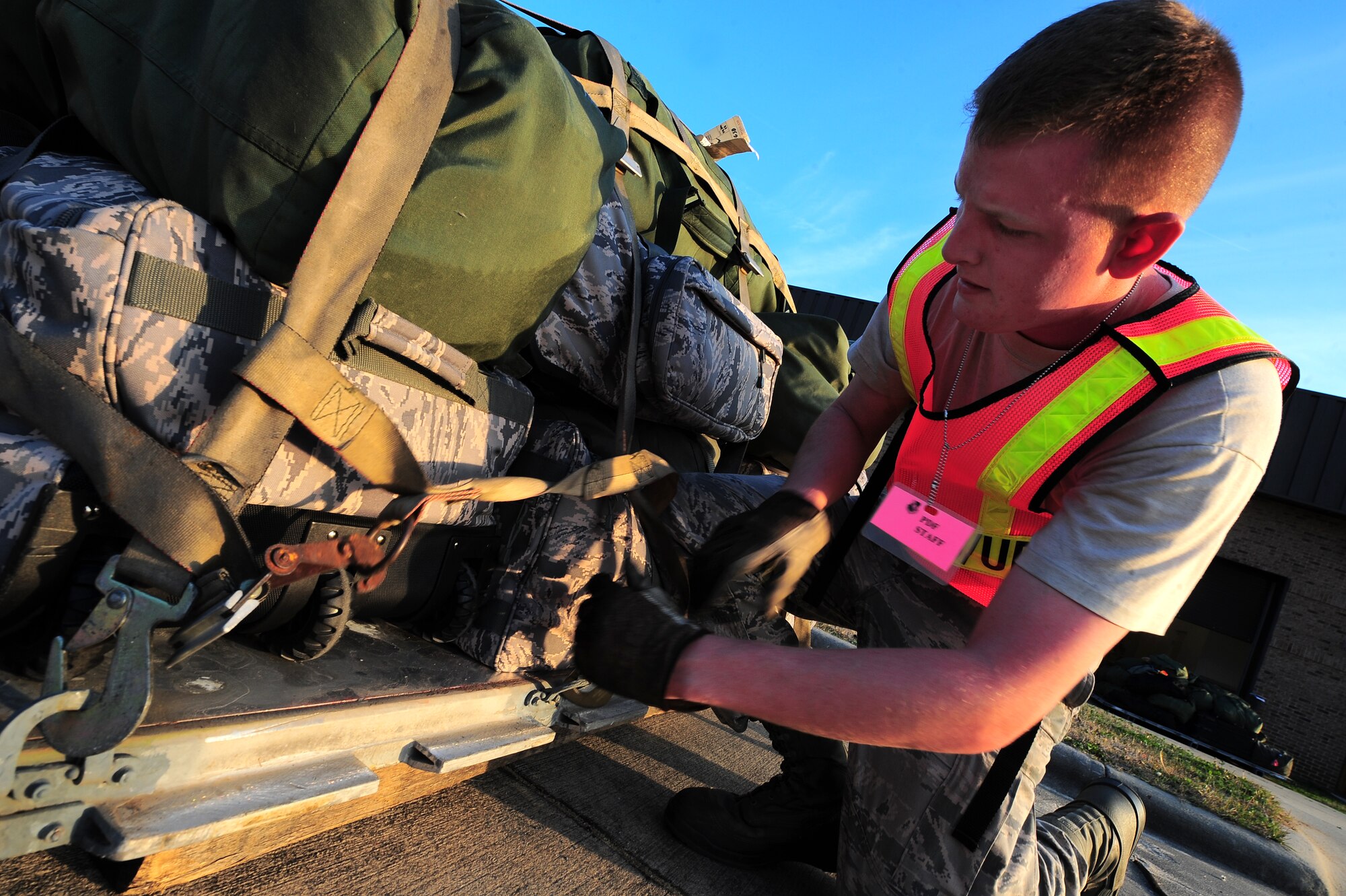 U.S. Air Force Airman 1st Class Benjamin Long, 4th Equipment Maintenance Squadron aircrew ground equipment maintainer, secures cargo onto a palette during Operational Readiness Exercise Coronet Warrior 13-04 at the Personnel Deployment Facility on Seymour Johnson Air Force Base, N.C., Jan. 14, 2013. The cargo was processed and simulated deployed during Phase I of the ORE. (U.S. Air Force photo/Airman 1st Class Aubrey White/Released)
