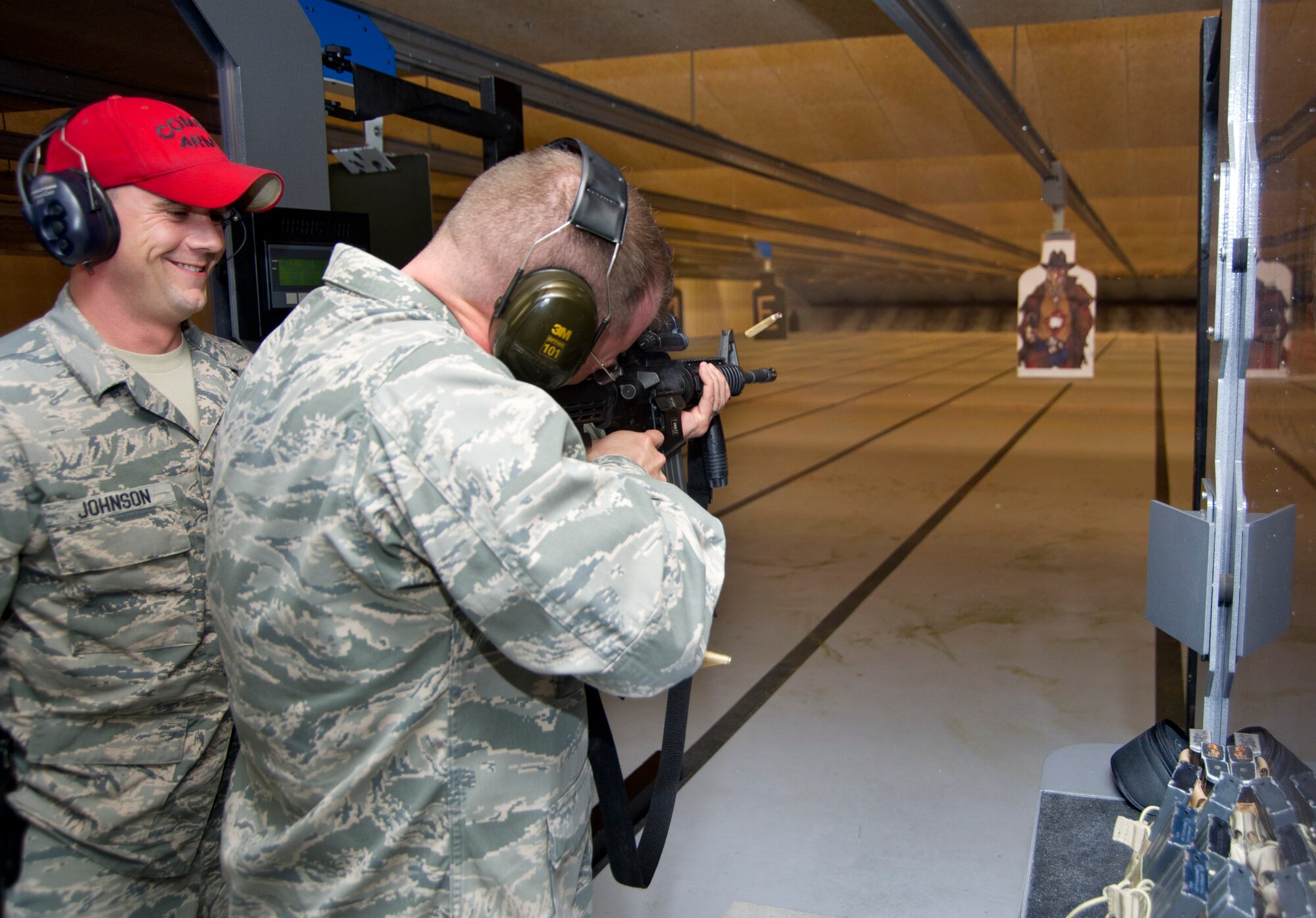 Col. John Kubinec, Installation Excellence Selection Board member, opens fire on a zombie cowboy target at the 81st Security Forces firing range with the assistance of Tech. Sgt. Jonathan Johnson, 81st SFS combat arms, Jan. 10, 2013, at Keesler Air Force Base, Miss.  Keesler is one of the top two bases competing for the Commander-in-Chief's Annual Award for Installation Excellence with a $1 million top prize for quality of life initiatives. Keesler showed the board members various examples of team problem solving, unit cohesiveness and enhanced productivity throughout their two-day visit.  (U.S. Air Force photo by Adam Bond)