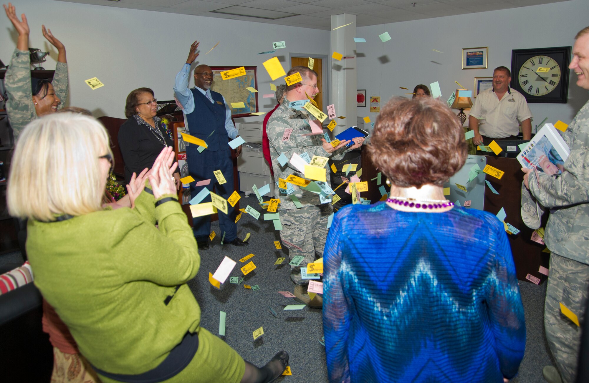 The Airman & Family Readiness Center exclaims, "Show me the money!" to Col. John Kubinec, Installation Excellence Selection Board member, as they shower him with fake money during his tour of the 81st Force Support Squadron Jan. 10, 2013, at the Sablich Center, Keesler Air Force Base, Miss.  Keesler is one of the top two bases competing for the Commander-in-Chief's Annual Award for Installation Excellence with a $1 million top prize for quality of life initiatives. Keesler showed the board members various examples of team problem solving, unit cohesiveness and enhanced productivity throughout their two-day visit.  (U.S. Air Force photo by Adam Bond)
