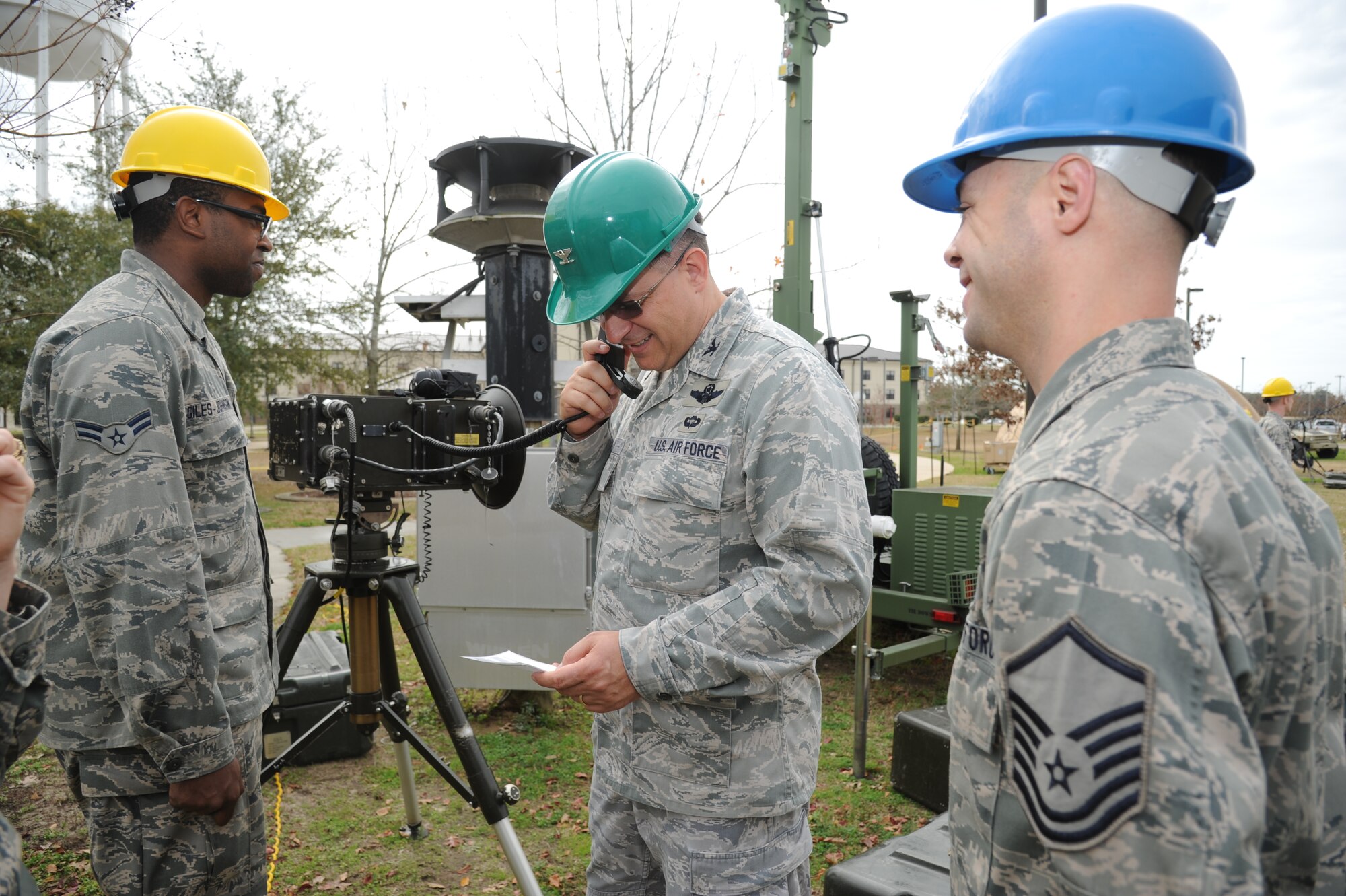 Airman 1st Class Tyler Giles-Johnson and Master Sgt. Tony Barattini, 338th Training Squadron, listen as Col. Albert Elton, Installation Excellence Selection Board member, center, uses a microwave radio for voice and data communication across the installation Jan. 11, 2013, at the Air Expeditionary Force  training area, Keesler Air Force Base, Miss.  Keesler is one of the top two bases competing for the Commander-in-Chief's Annual Award for Installation Excellence with a $1 million top prize for quality of life initiatives.  Keesler showed the board members various examples of team problem solving, unit cohesiveness and enhanced productivity throughout their two-day visit.  (U.S. Air Force photo by Kemberly Groue)