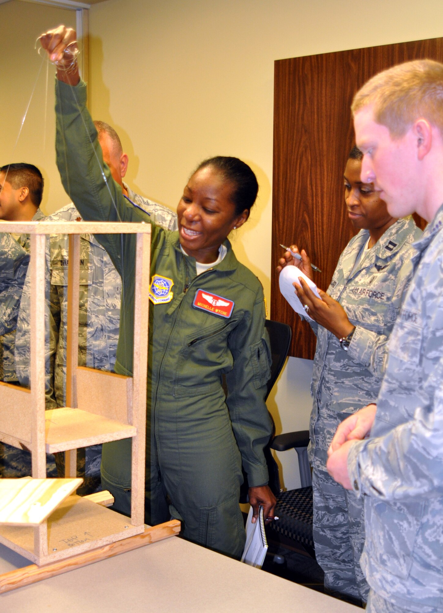 Maj. Michelle Wyche, 375th Aeromedical Evacuation Squadron's clinical management flight commander, tests out the elevator lift prototype during a collaboration workshop Jan. 15, 2013 at Scott AFB, Ill.  A group of Air Force Academy seniors designed patient loading system prototypes so that medical personnel would be able to feel and see how they work, and provide feedback to the designers.  (U.S. Air Force photo/Staff Sgt. Maria Bowman)