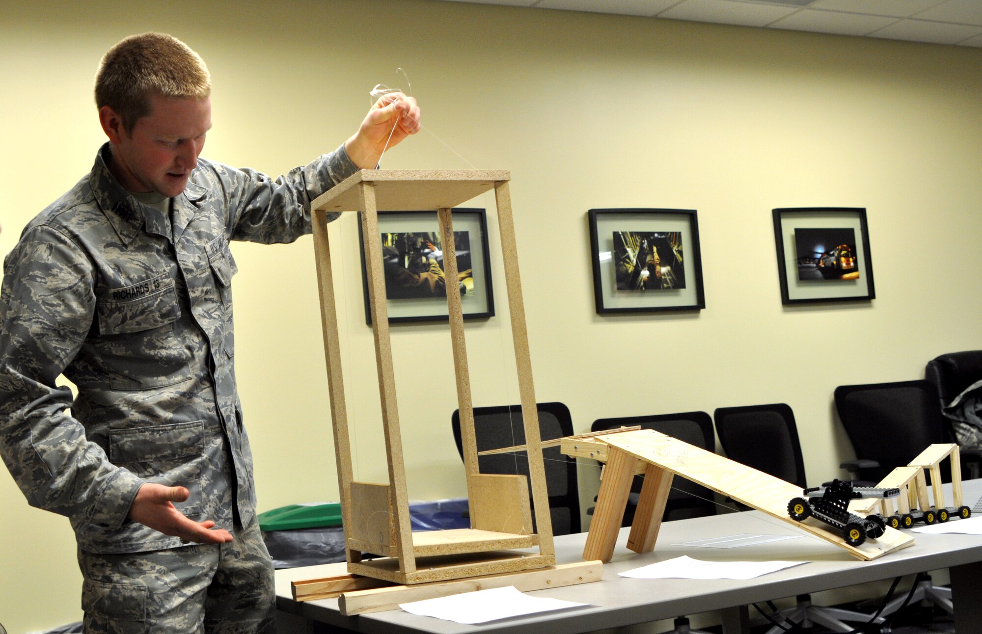 Cadet 1st Class Hayden Richards demonstrates how the elevator lift works during the workshop Jan. 15, 2013 at Scott AFB, Ill.  A small group of Air Force Academy seniors designed prototypes of patient loading systems, which help medical personnel get patients into planes.  (U.S. Air Force photo/Staff Sgt. Maria Bowman)