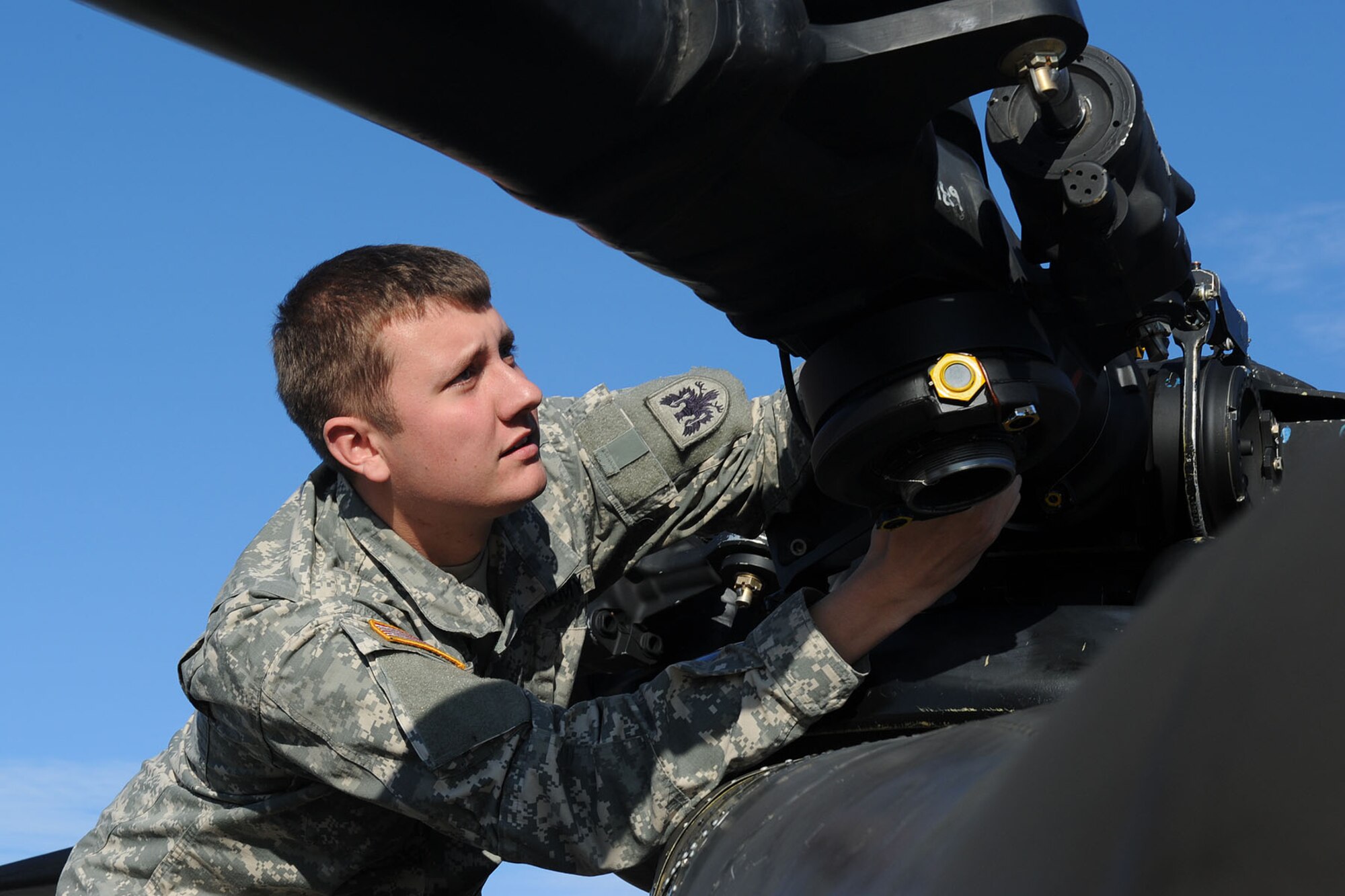 U.S. Army Reserve Spc. Dustin Campbell, a CH-47 Chinook crew chief assigned to the 5th Battalion, 159th Aviation Regiment, inspects the aft rotor system of a CH-47 on the tarmac at Fort Eustis, Va., Jan. 10, 2013. Campbell is one of several Reservists serving on active duty orders in support of the Defense CBRN Response Force mission, in which the battalion will deploy eight aircraft and up to 150 personnel within a 24-hour period anywhere in the nation to support relief efforts following catastrophic terrorist or natural disaster events. (U.S. Air Force photo by Staff Sgt. Ashley Hawkins/Released)
