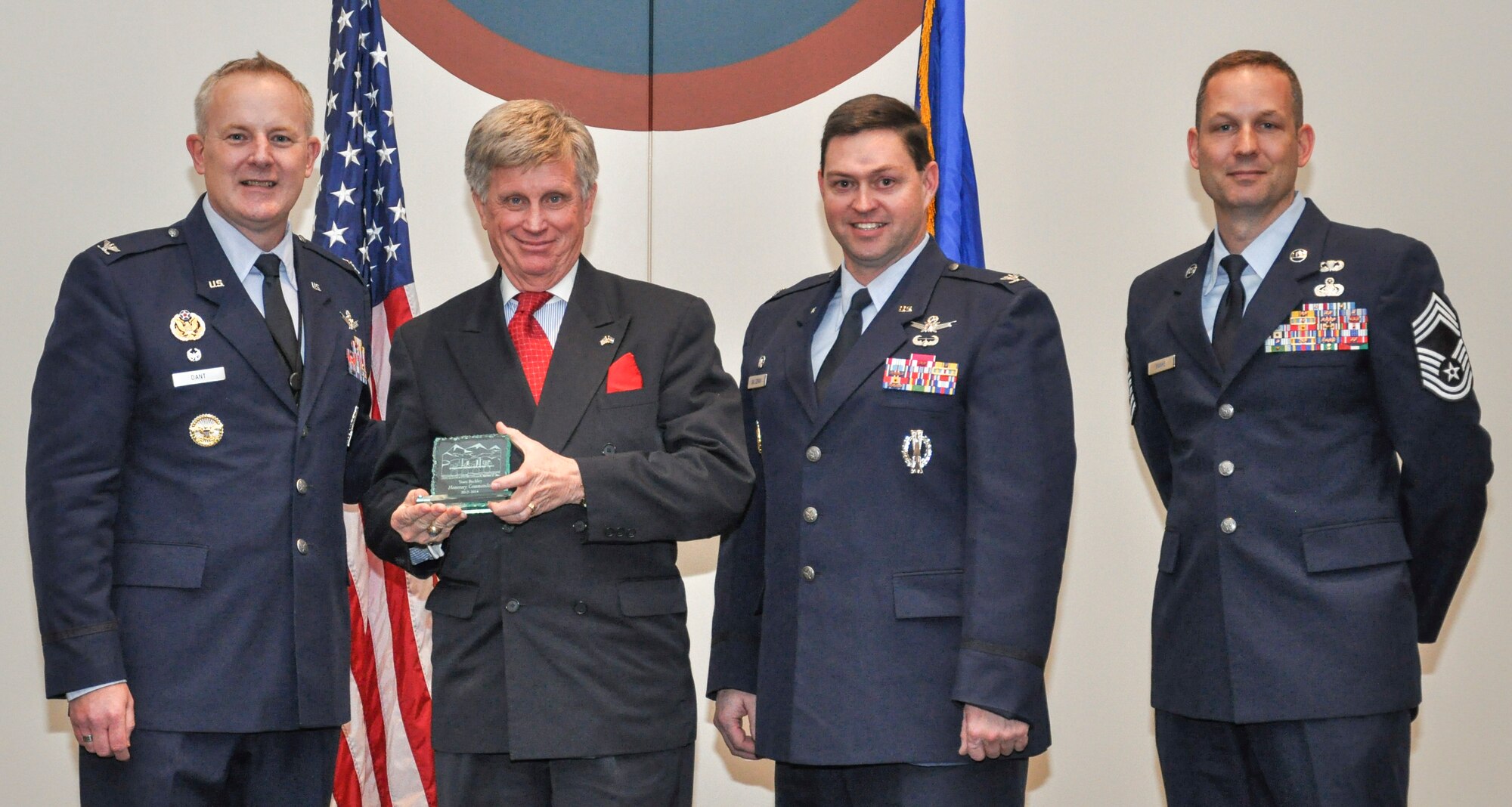 Tom Allee, Frontier Airlines and community commander, receives his induction memento from Col. Daniel Dant, 460th Space Wing commander, at a Community Commander Induction Ceremony Jan 11, 2013, at the Buckley Leadership Development Center. Dant reminded the civilians that staying connected with their military commanders will give them a real opportunity to impact national defense. (U.S. Air Force photo by Staff Sgt. Nicholas Rau/Released)