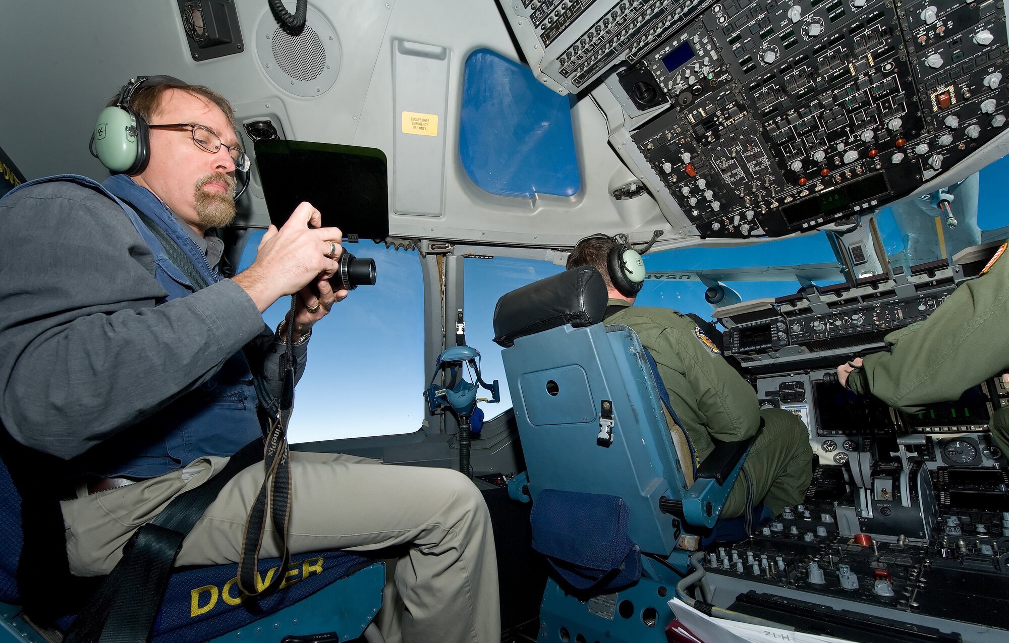 Randall Chase, left, a reporter for the Associated Press, photographs Capts. James Blinn, left, and Jonathan Weaver, right, pilots with the 3rd Airlift Squadron, Dover Air Force Base, Del., as they perform air refueling duties Jan. 7, 2013, over New England. Chase and 11 other media representatives observed an air refueling mission with a KC-135R from the 101st Air Refueling Wing, Bangor, Maine, during an orientation flight. (U.S. Air Force photo/Roland Balik)

