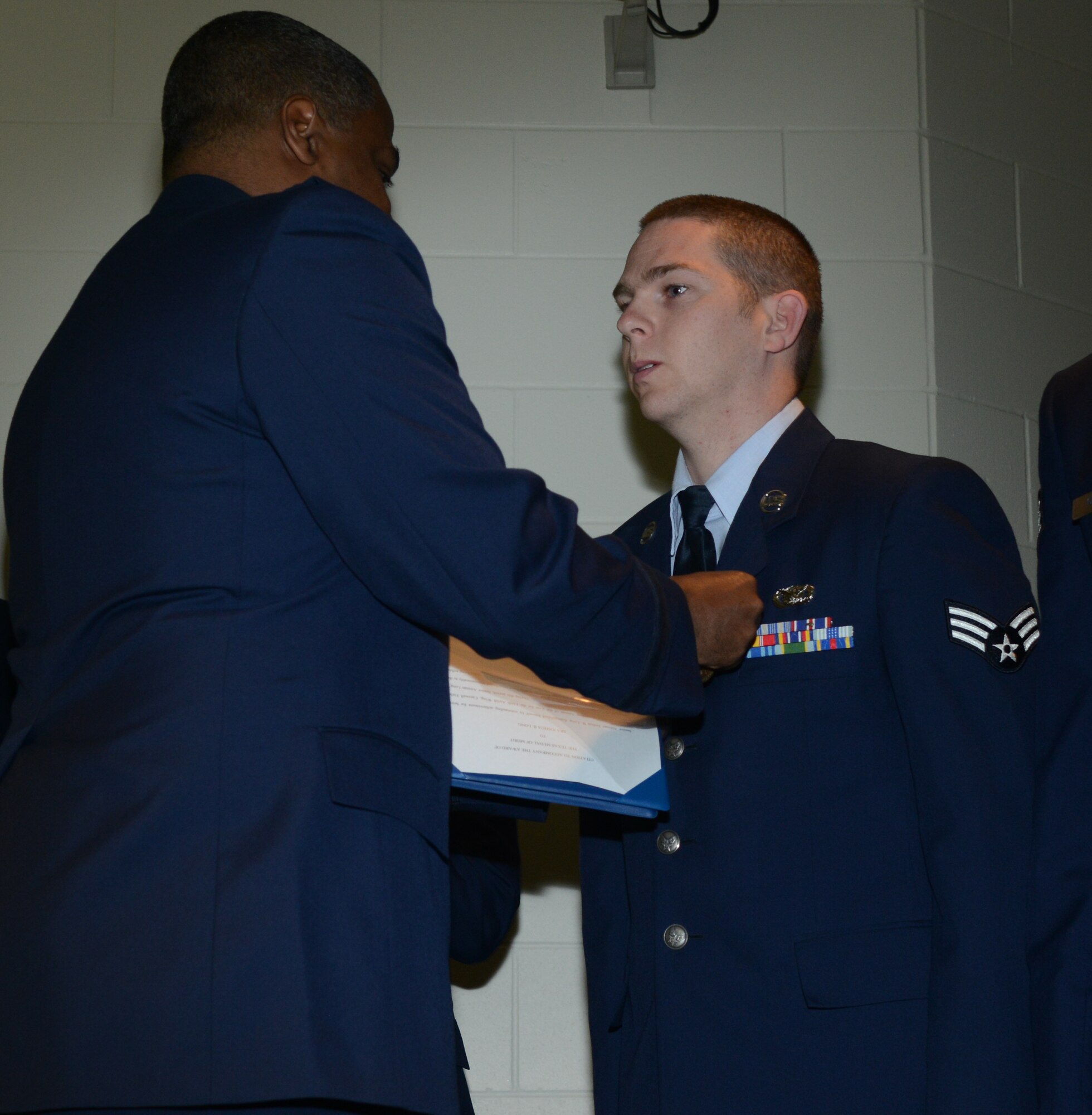Brig. Gen. Brian Newby, chief of staff for the Texas Air National Guard pins the Texas Medal of Merit on Senior Airman Joushua Long, 136th Airlift Wing Airman of the Year for his outstanding performance in the Wing. Long competed amongst fellow Airmen thoughout the State. (National Guard photo by Senior Master Sgt. Elizabeth Gilbert)