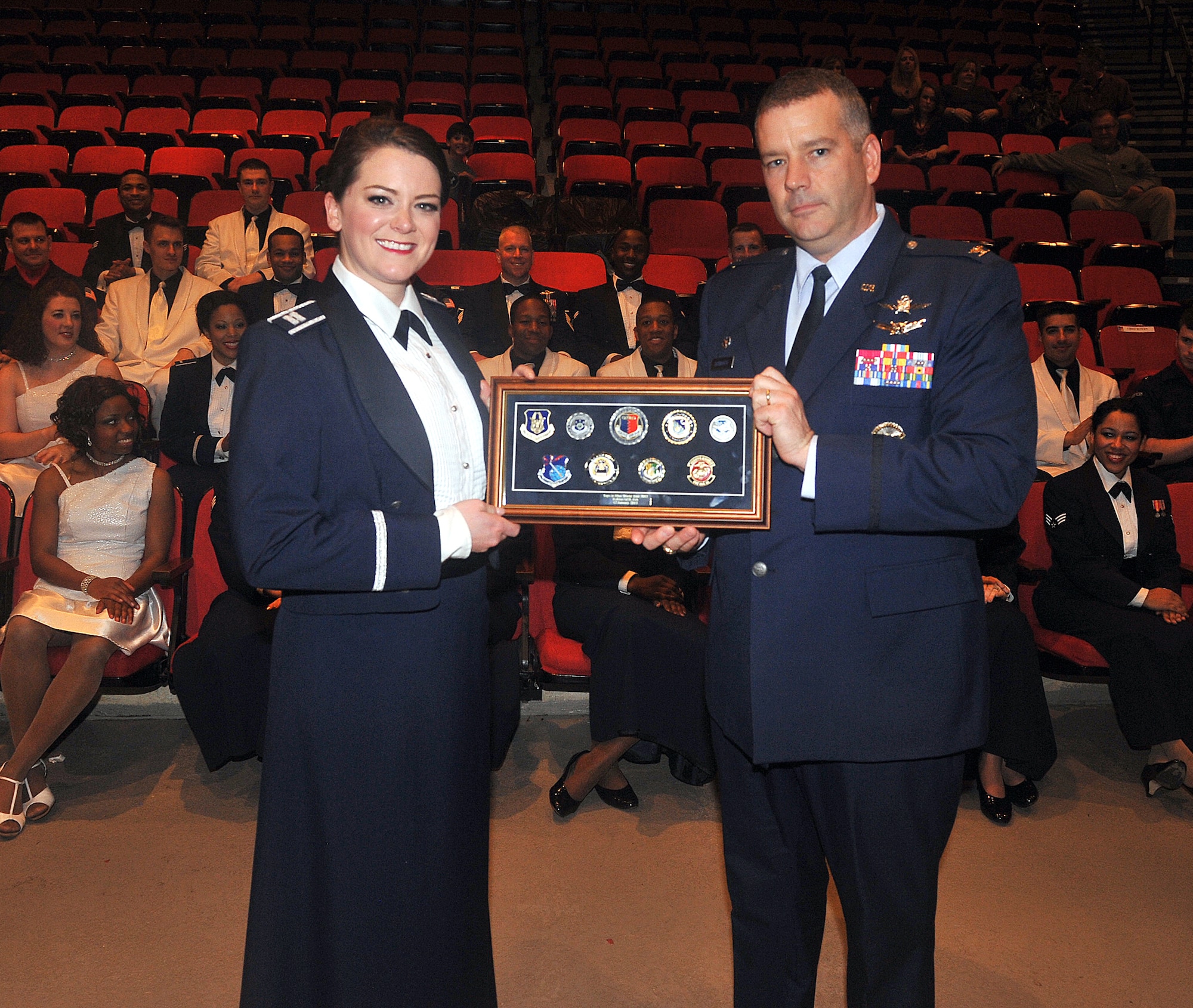 Col. Mitch Butikofer, 78th Air Base Wing commander, presents a coin case to Tops in Blue following the performance at a packed Warner Robins Civic Center Jan. 12.